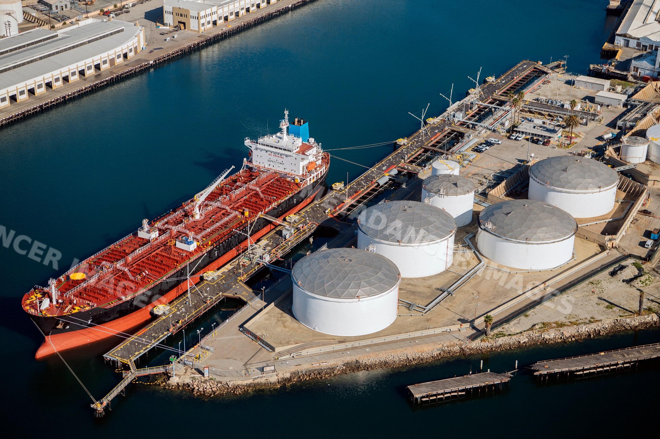Oil tanker docked at fuel storage tanks in california port