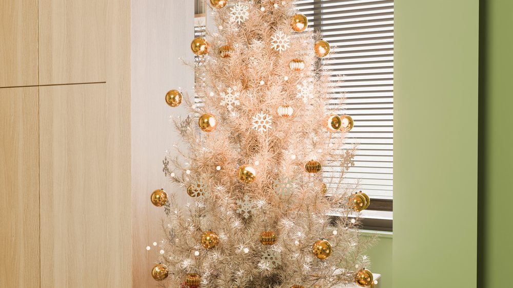 Christmas tree with gold ornaments and snowflake decorations indoors