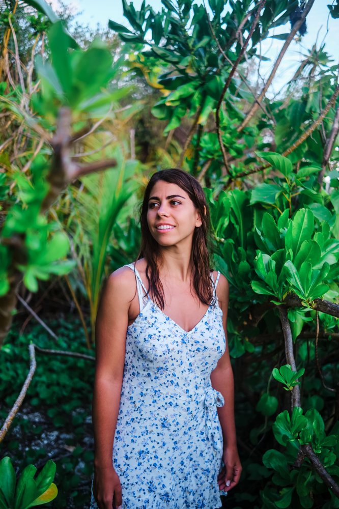 Young white woman smiling among tropical plants