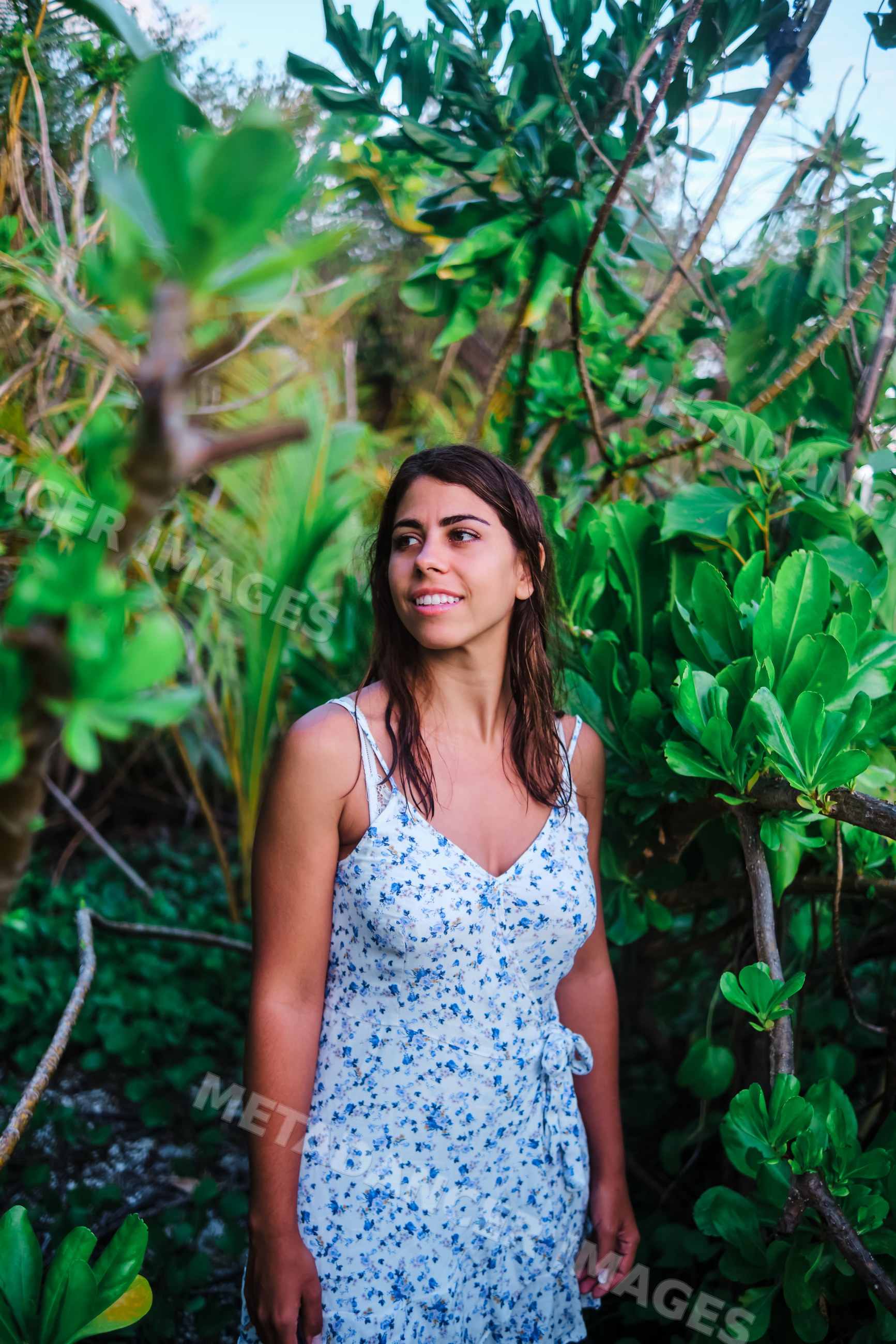 Young white woman smiling among tropical plants