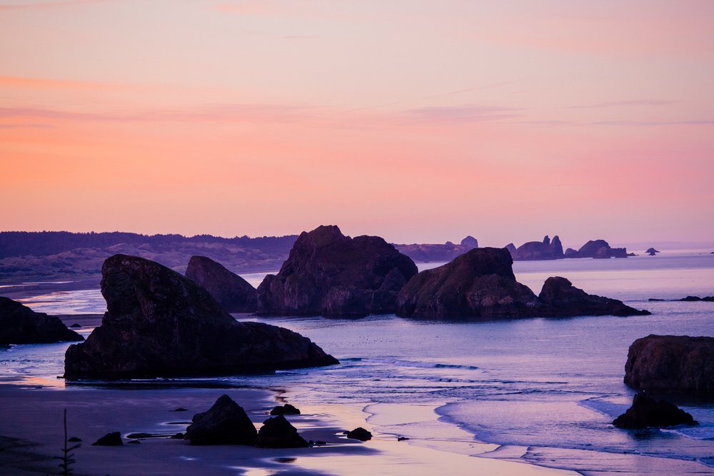 Coastal rock formations at ocean shoreline during sunset