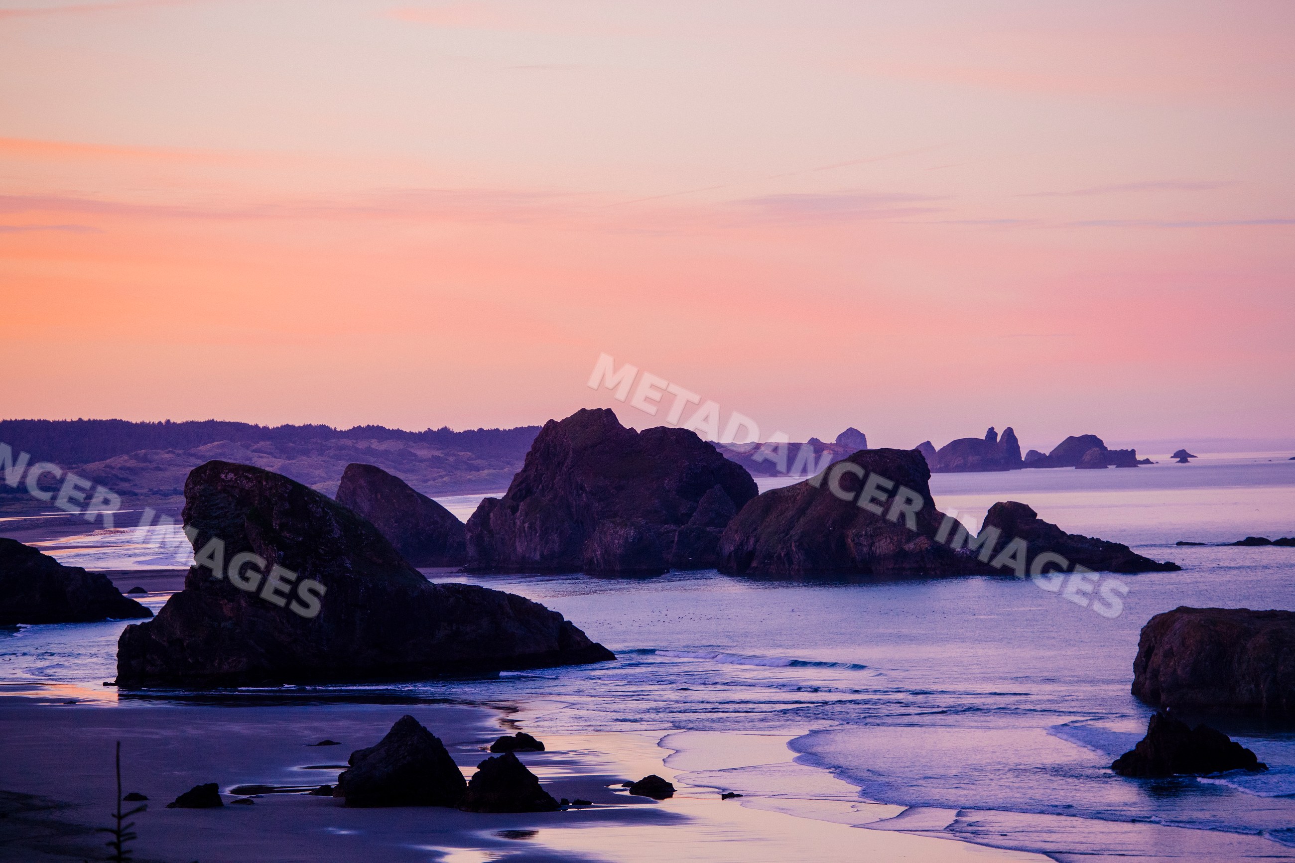 Coastal rock formations at ocean shoreline during sunset
