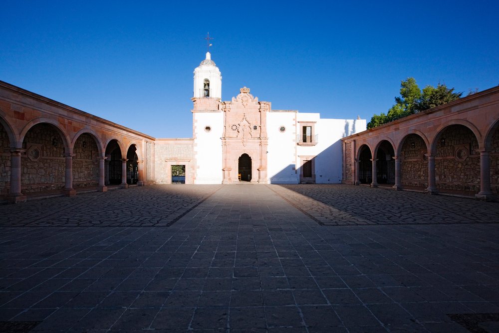 Church courtyard with bell tower and stone arches