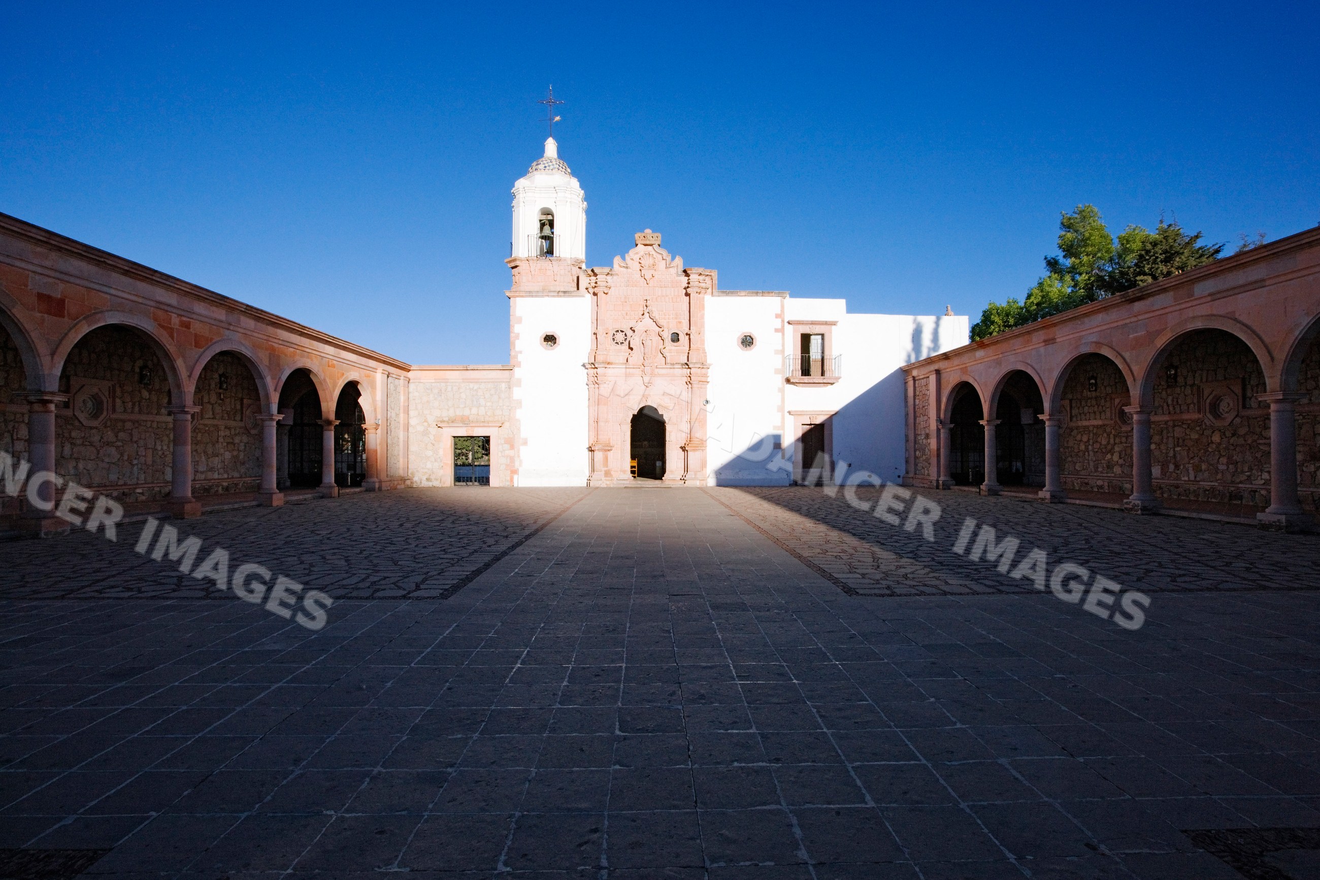 Church courtyard with bell tower and stone arches