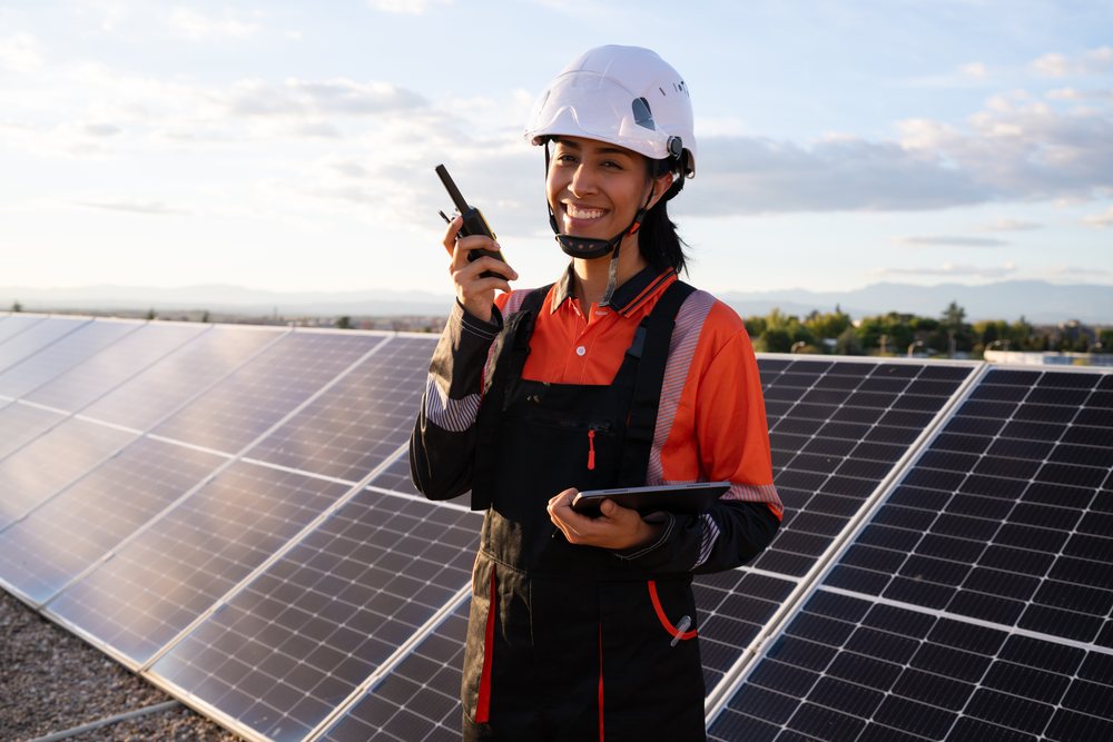 Solar energy technician inspecting photovoltaic panels outdoors