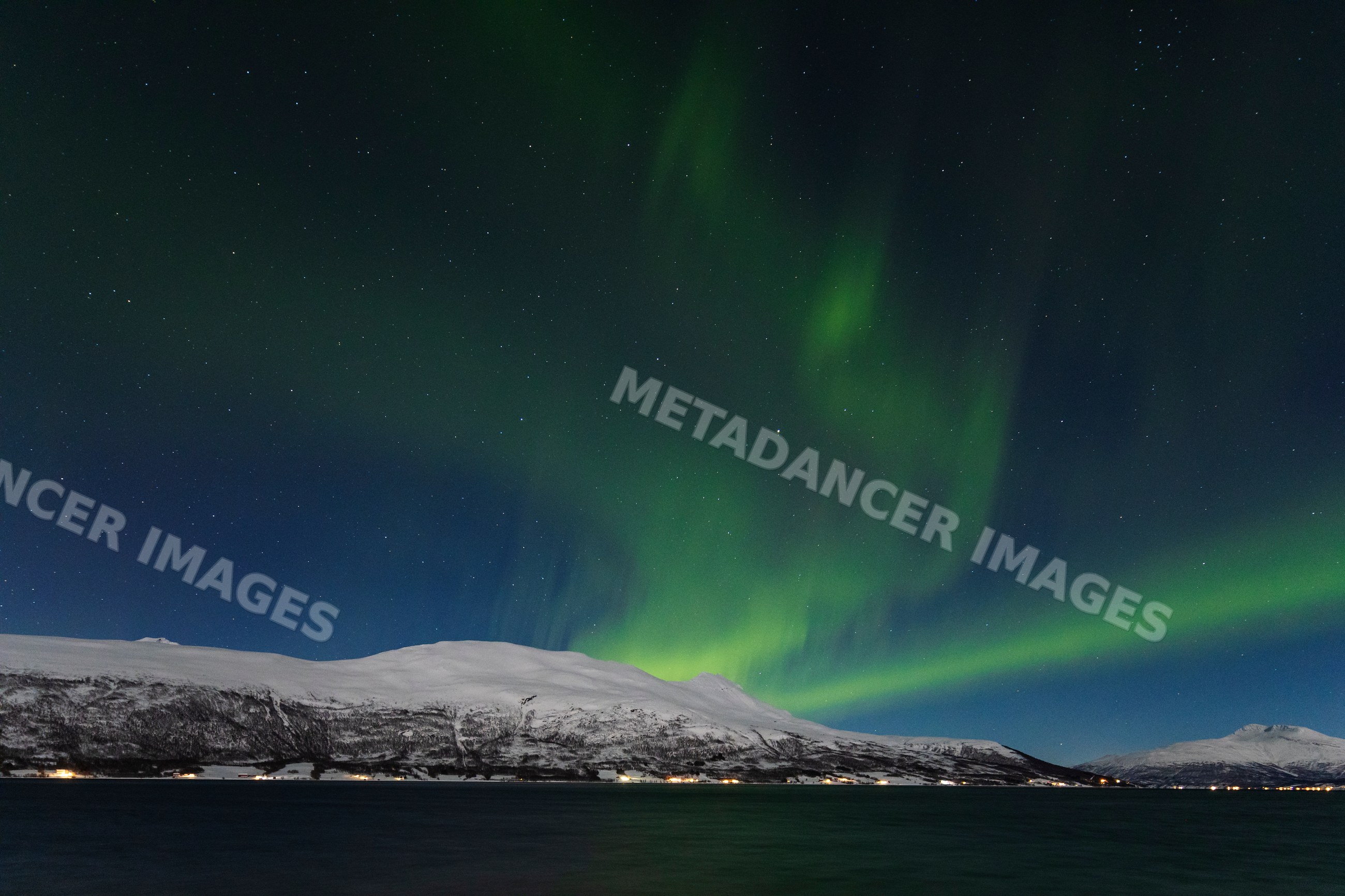 Northern Lights over snowy mountains and balsfjorden