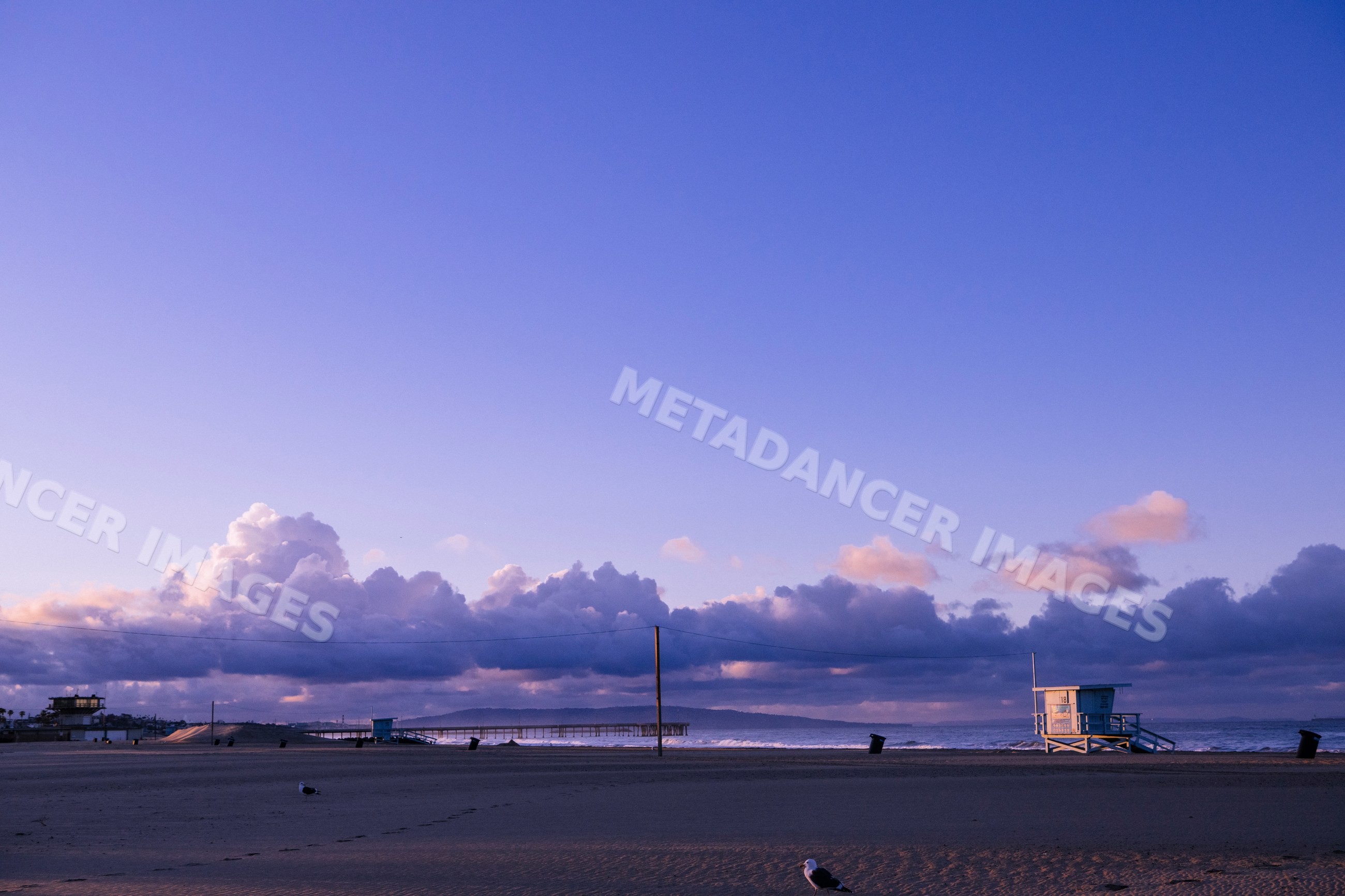 Venice Beach shoreline with lifeguard towers at sunset in california