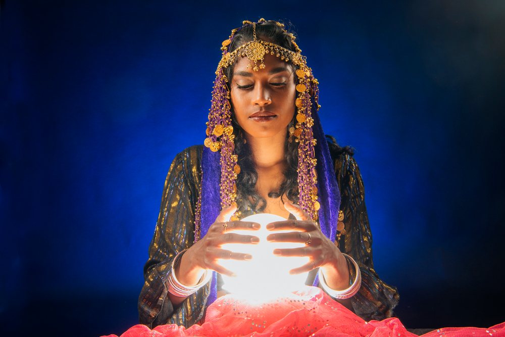 A fortune teller holding a glowing crystal ball in a mystical setting