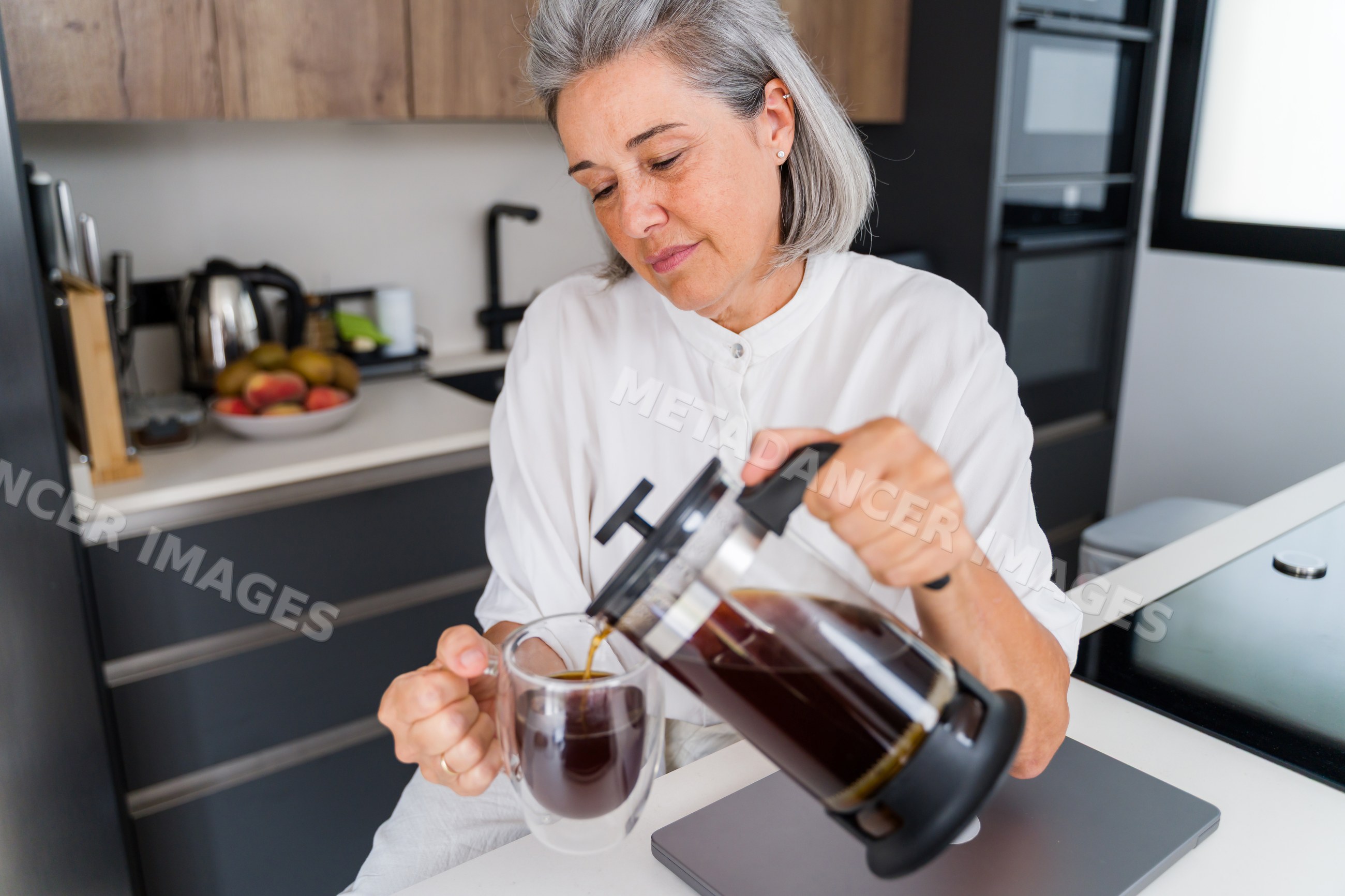 Middle-aged white woman pouring coffee with manual coffee maker