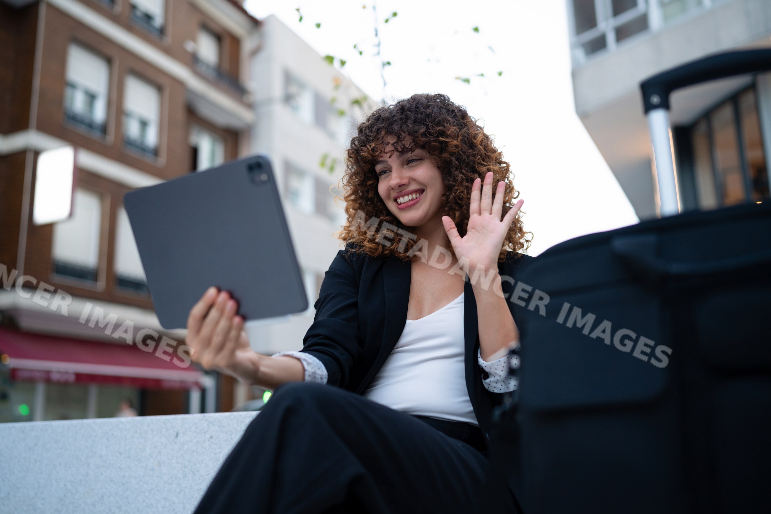 Young white woman making a video call outdoors in an urban setting
