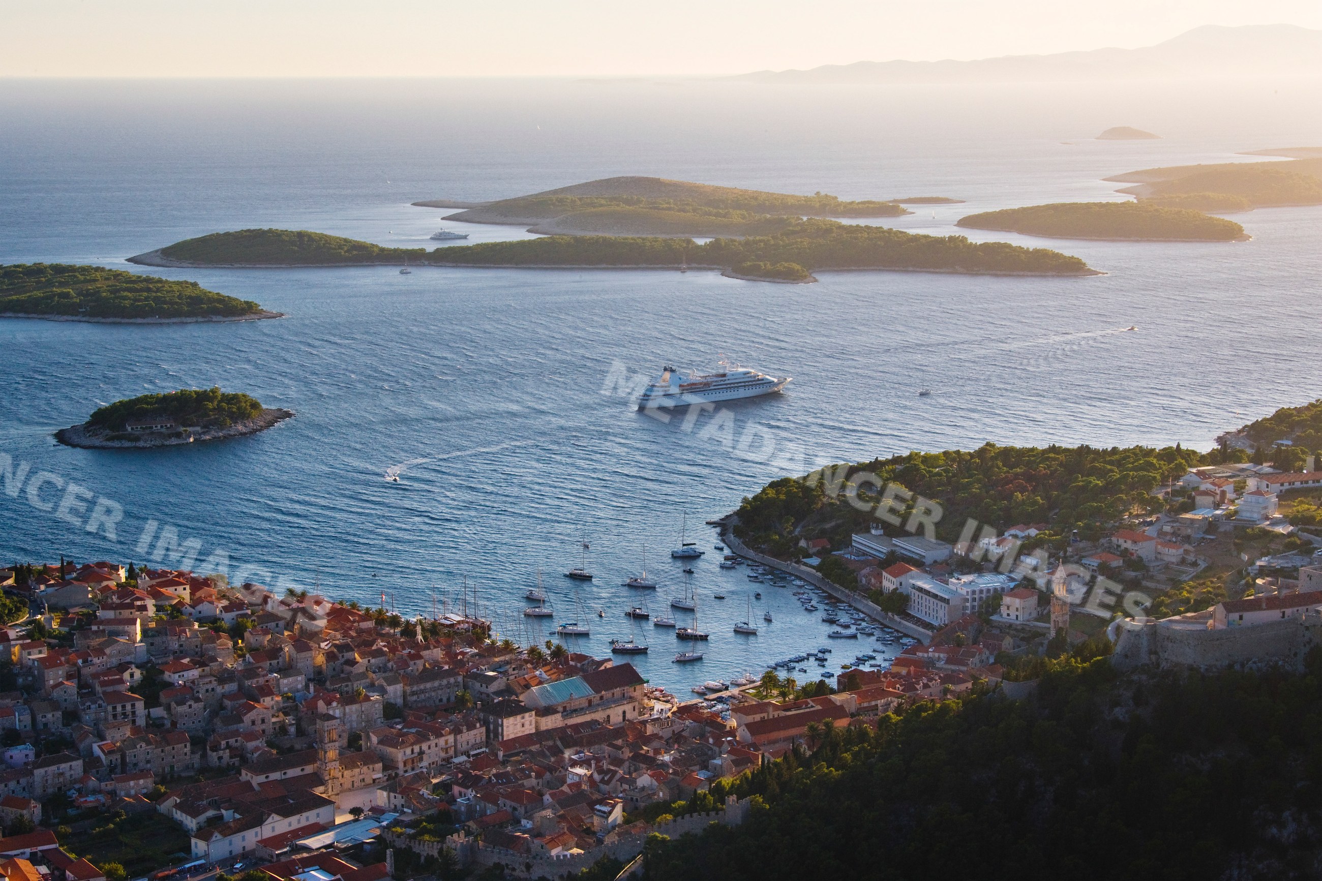 Hvar harbor with boats and cruise ship among islands