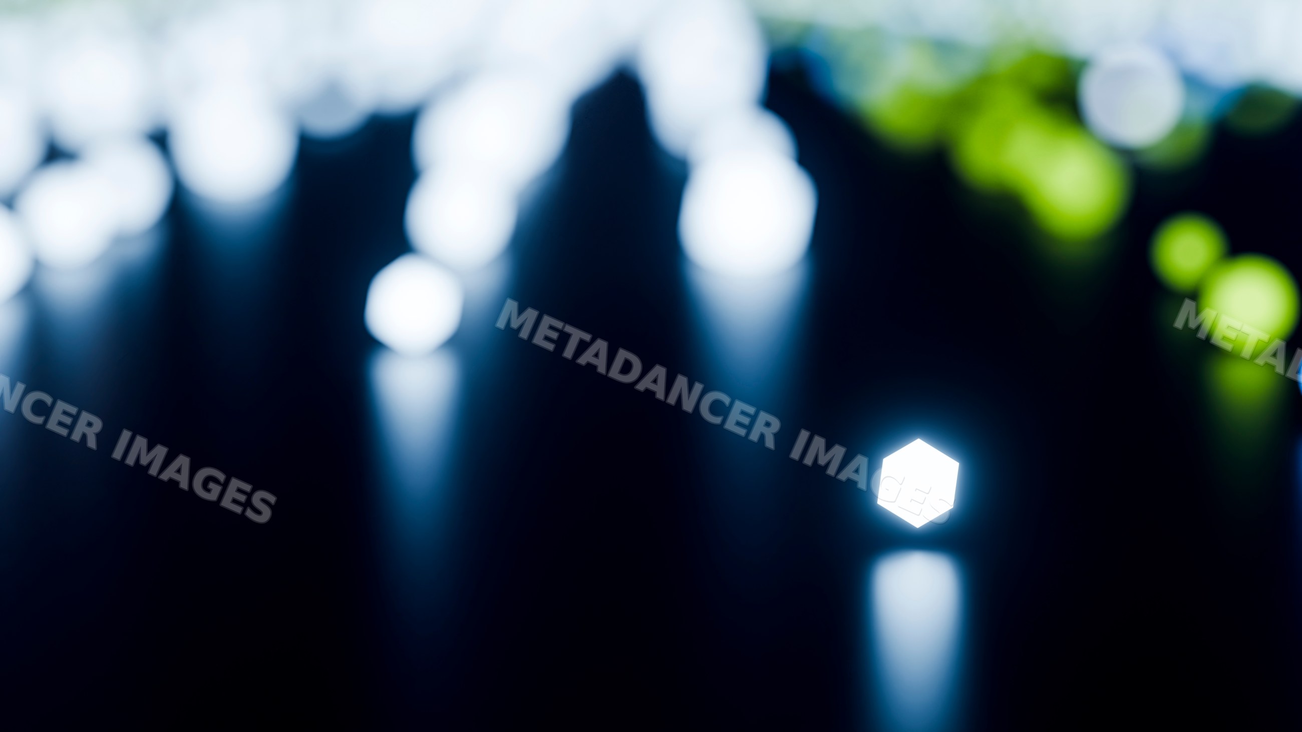 Glowing hexagon light with bokeh reflections on dark surface