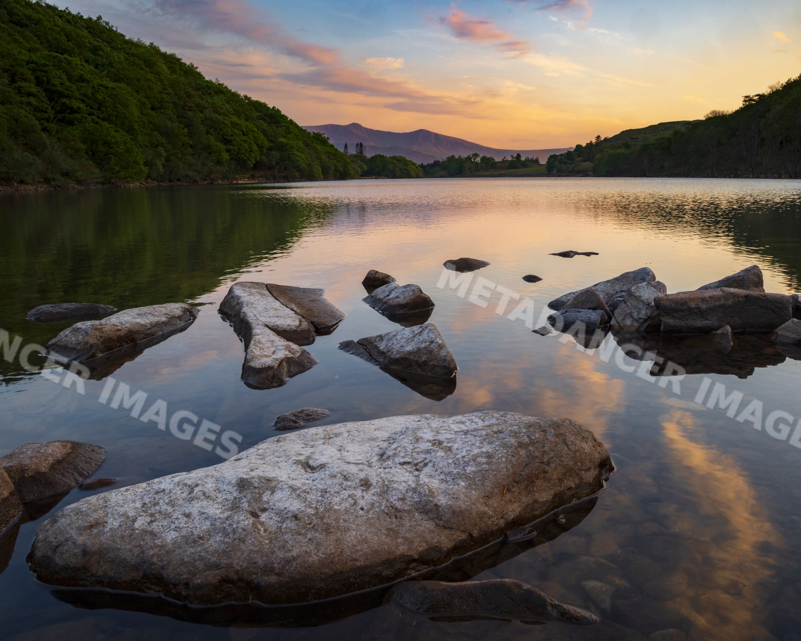 Lake llyn cuinwch at Sunset with calm water and rocks in dolgellau