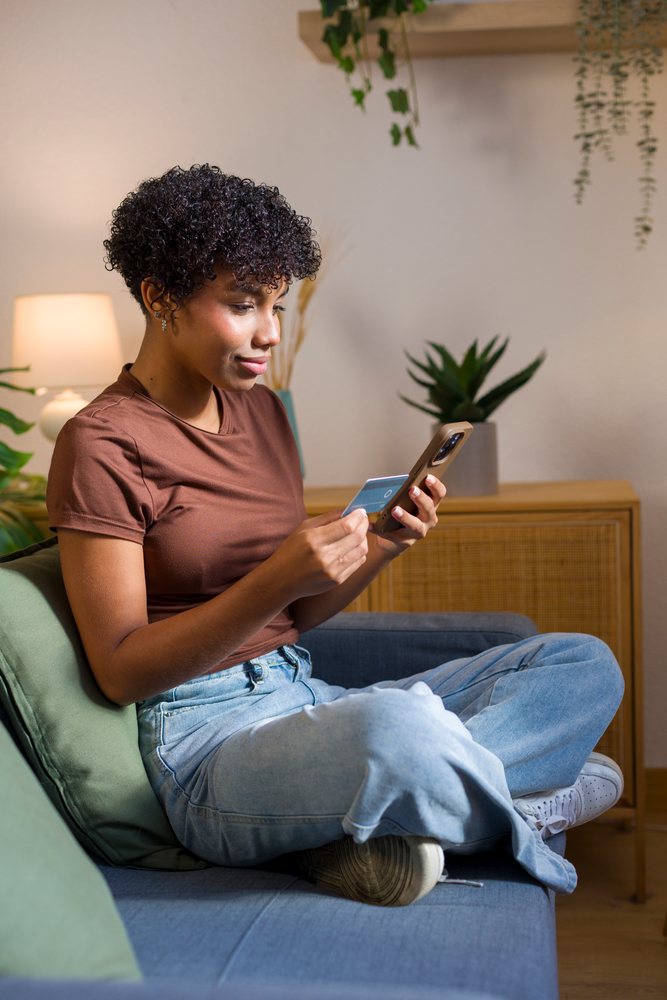 African American woman using smartphone and credit card