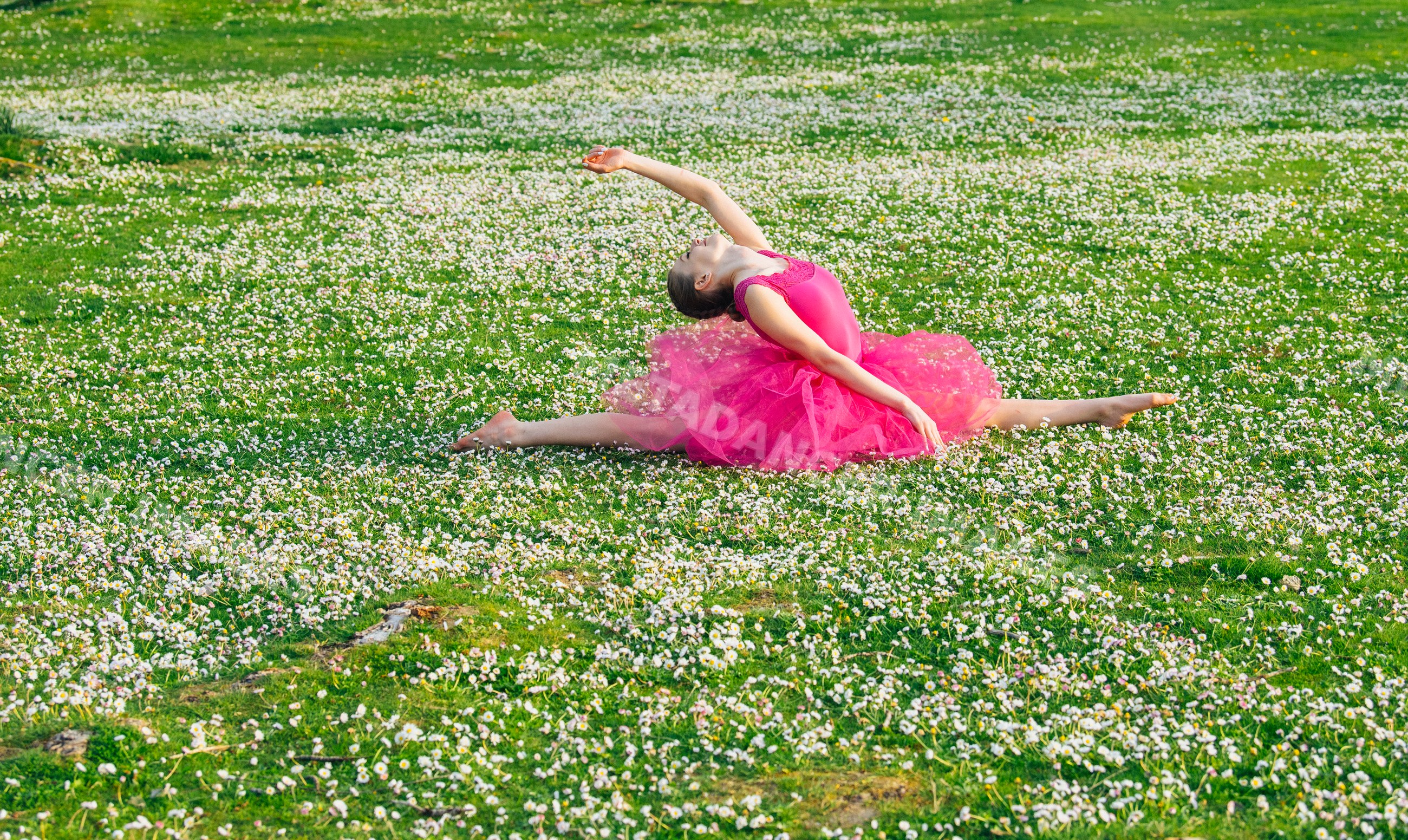 Ballet white dancer performing split stretch outdoors