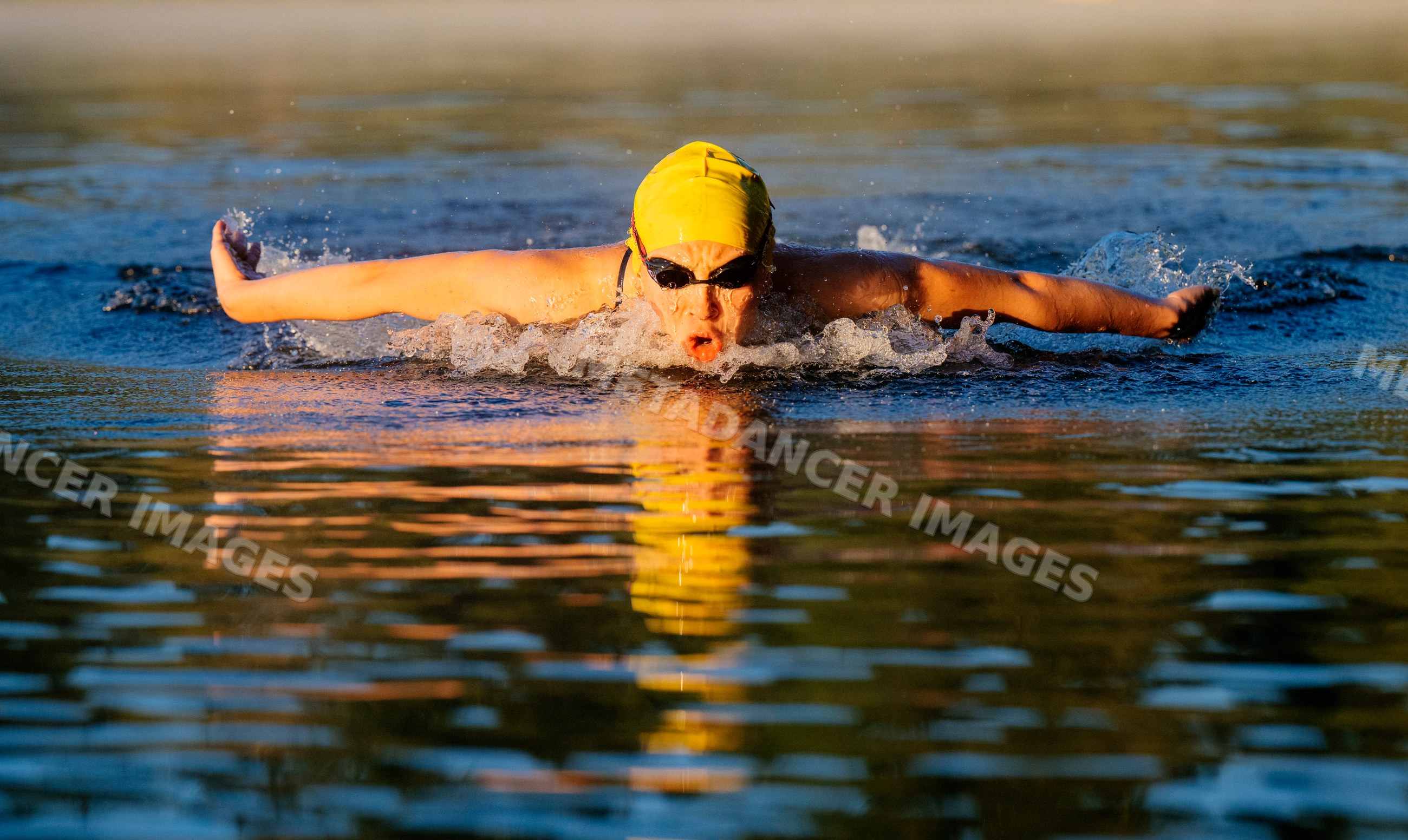 White swimmer performing butterfly stroke in open water