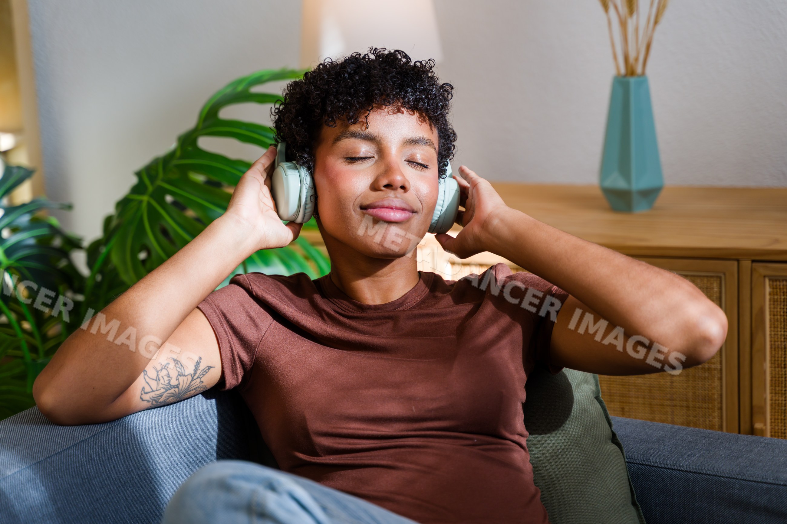 African American woman relaxing indoors listening to music