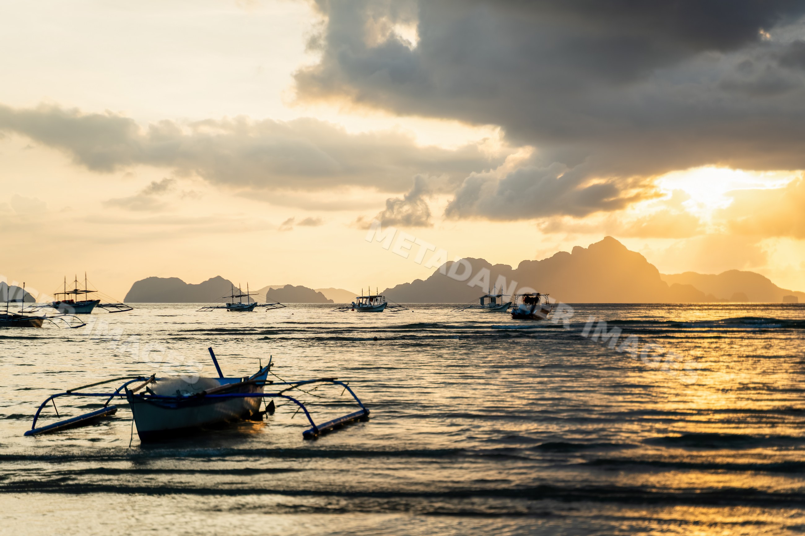 Fishing boats at sunset on the sea with distant islands
