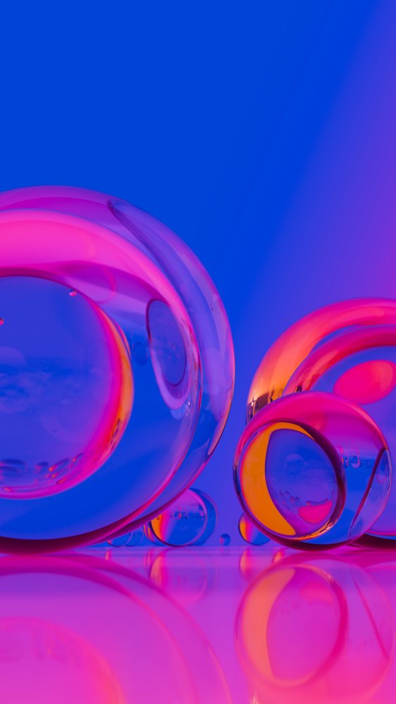 Colorful transparent glass spheres with reflections on shiny surface