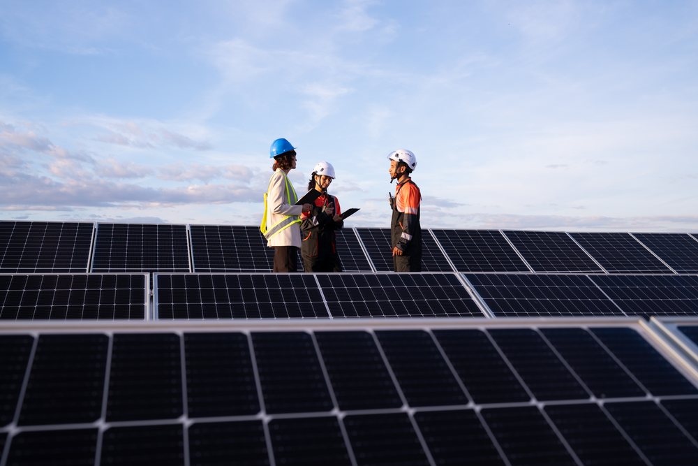 Hispanic and white workers inspecting solar panels