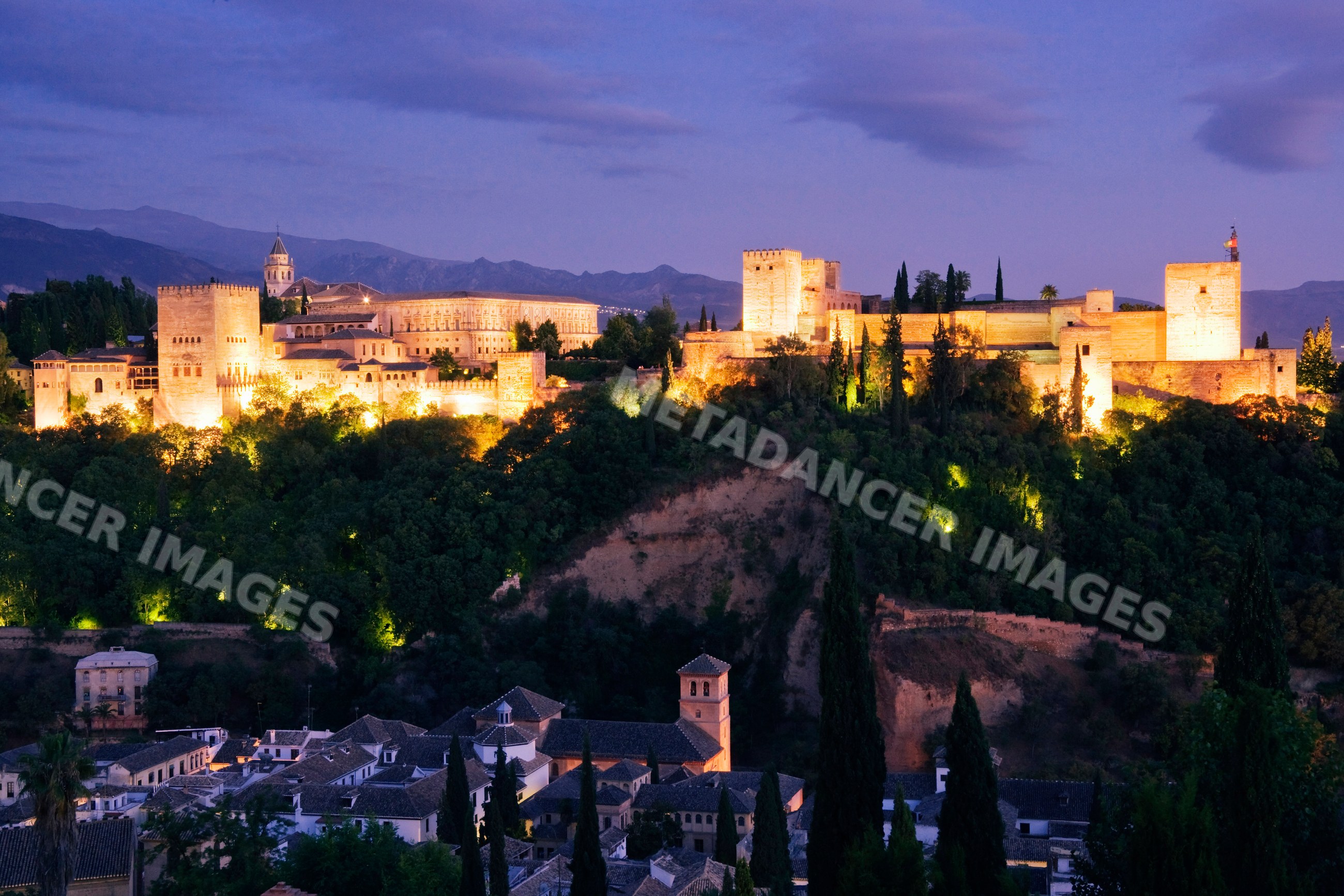 Alhambra fortress illuminated at twilight overlooking granada Spain