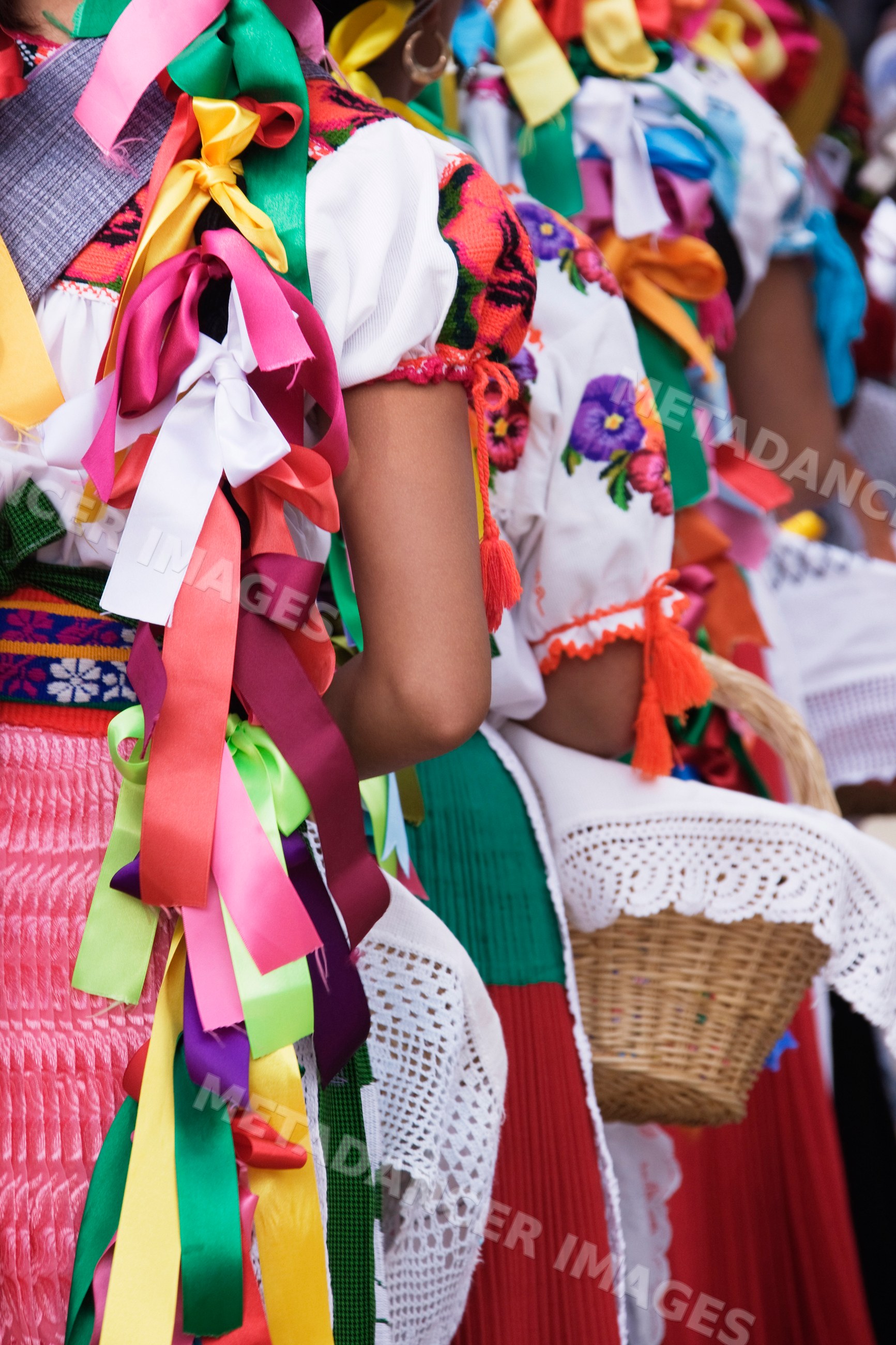 Purepecha young women in colorful festival costumes with ribbons
