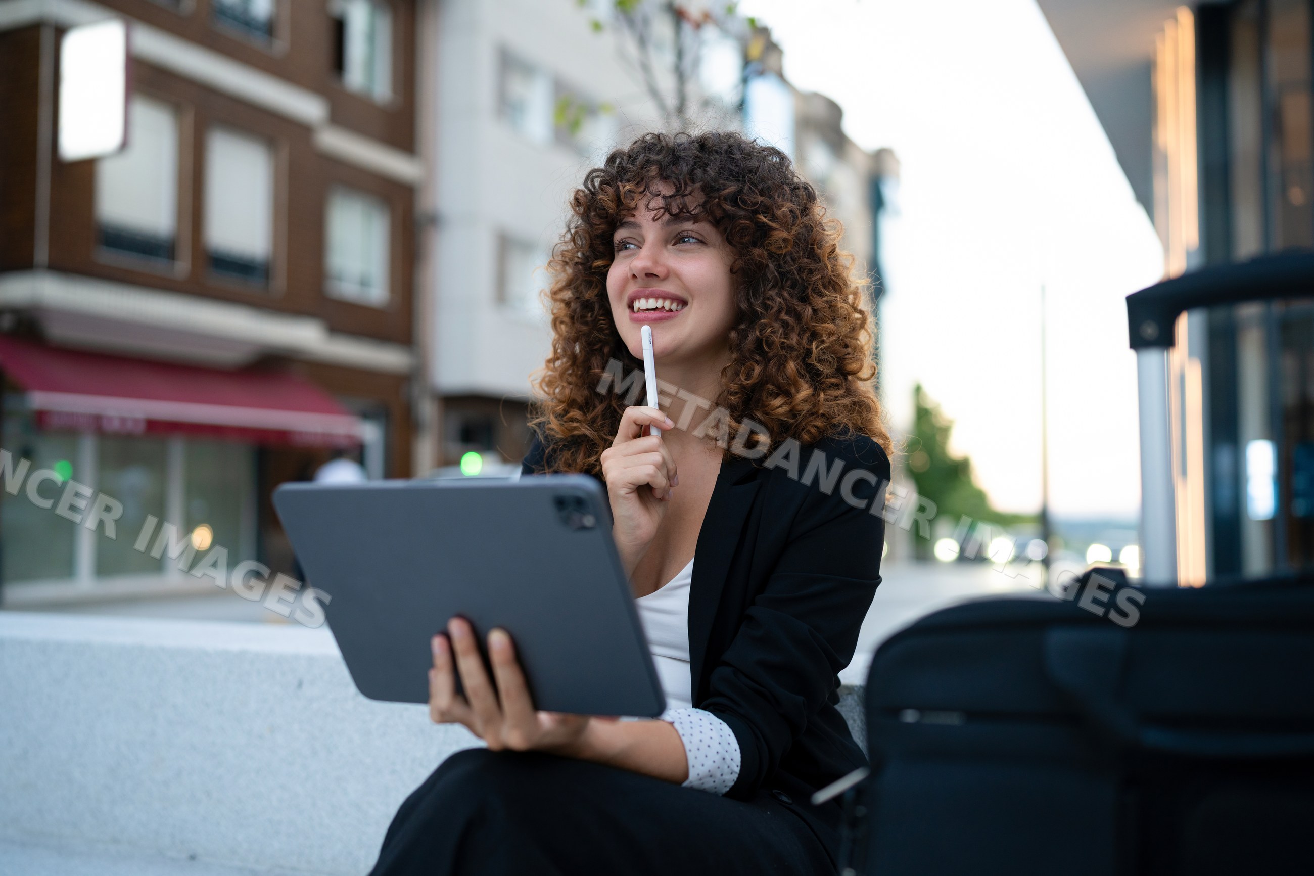 White woman holding tablet and thinking outdoors in Madrid urban area