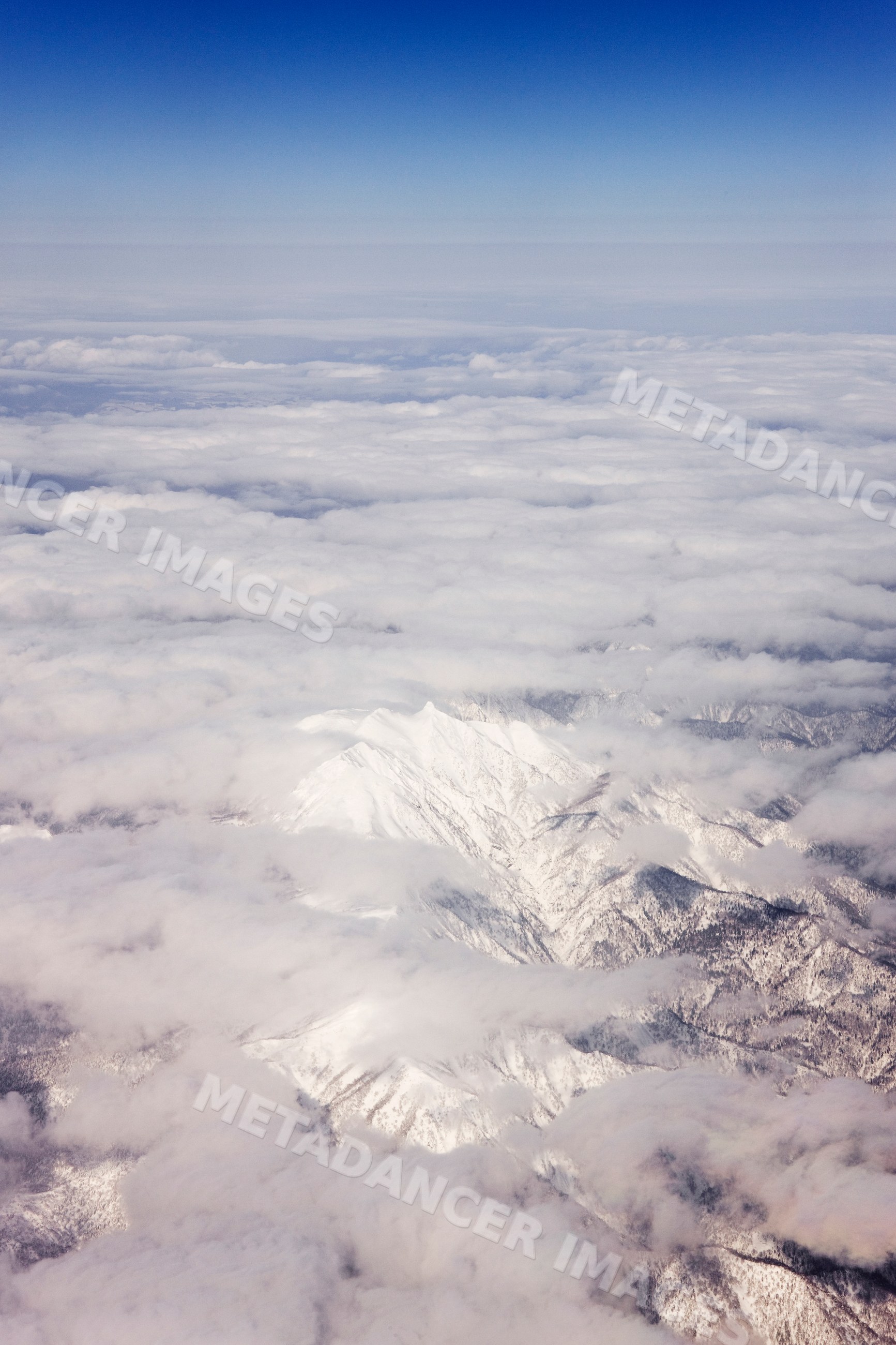 Aerial view of snow-covered mountains and clouds, japan
