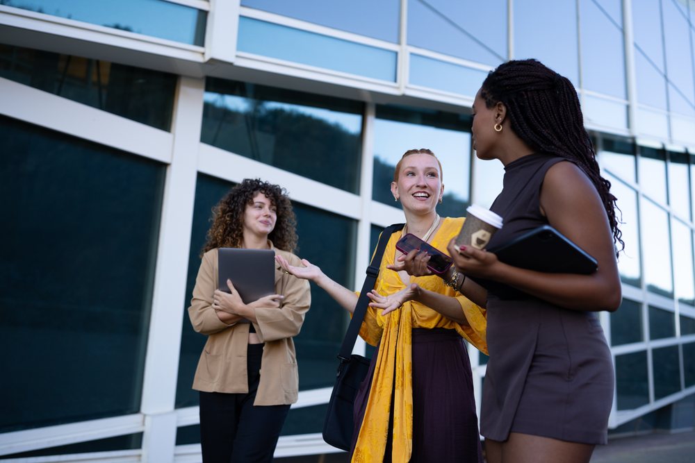 African American and white women conversing outdoors with digital