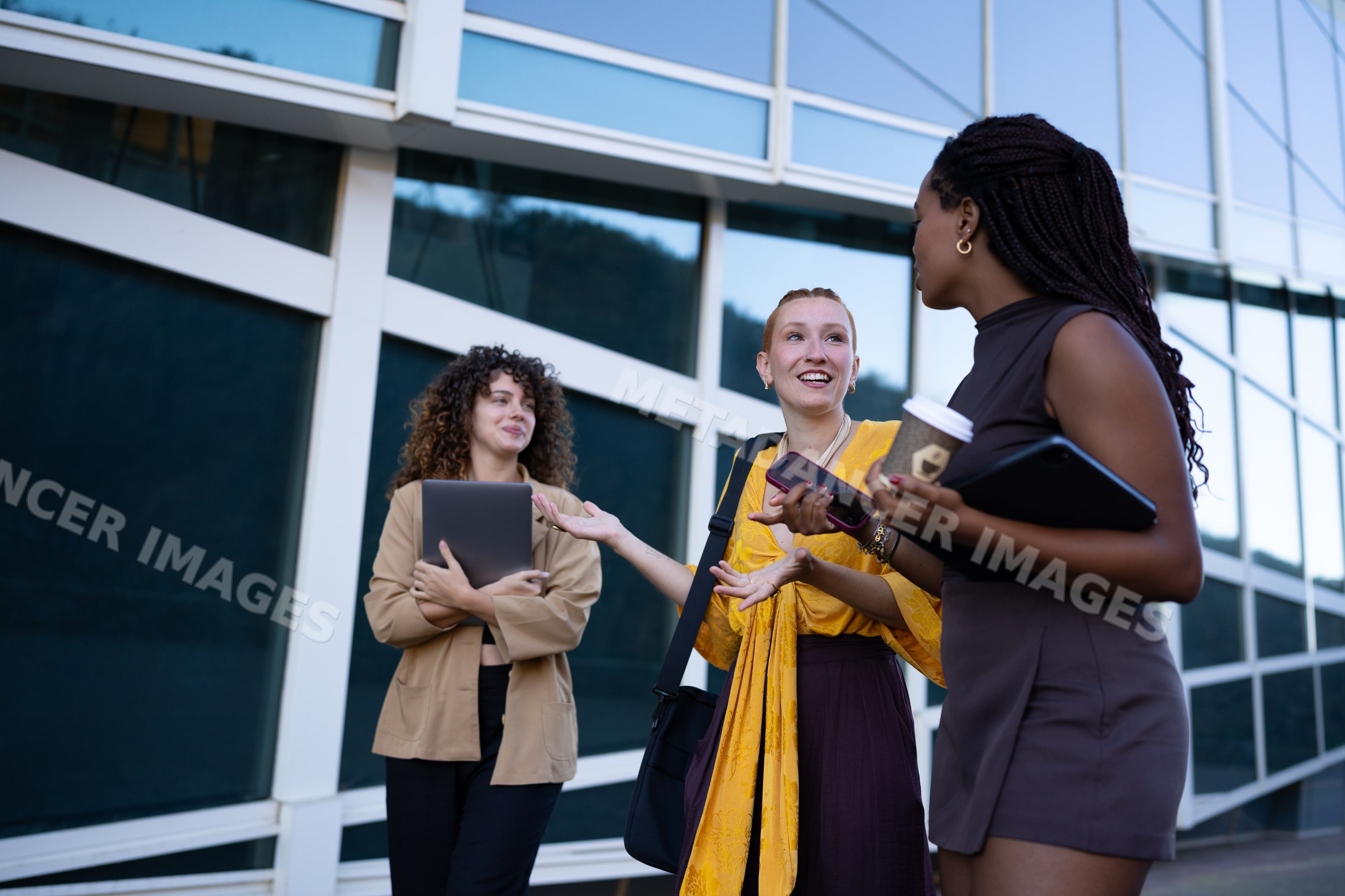 African American and white women conversing outdoors with digital