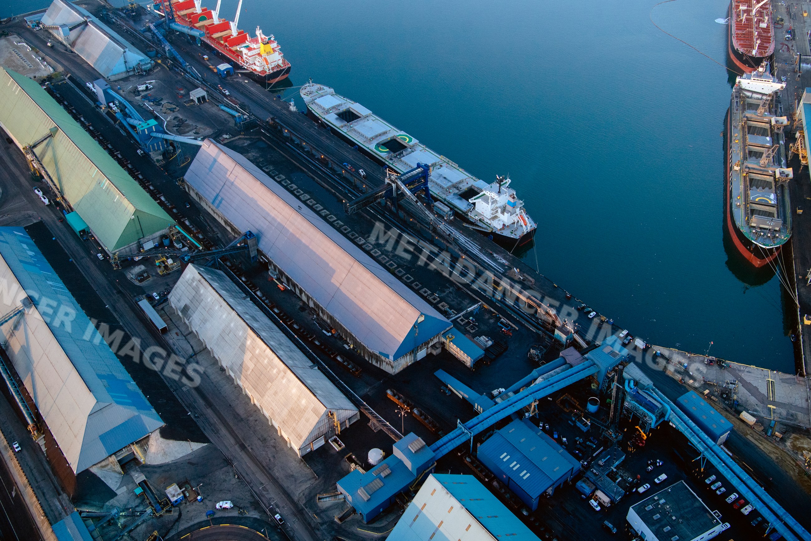 Aerial view of cargo ships docked at a large industrial port facility