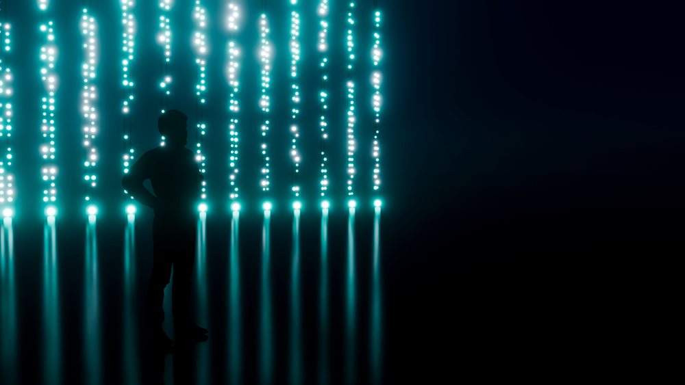 Silhouette of man with vertical blue light strands on dark background