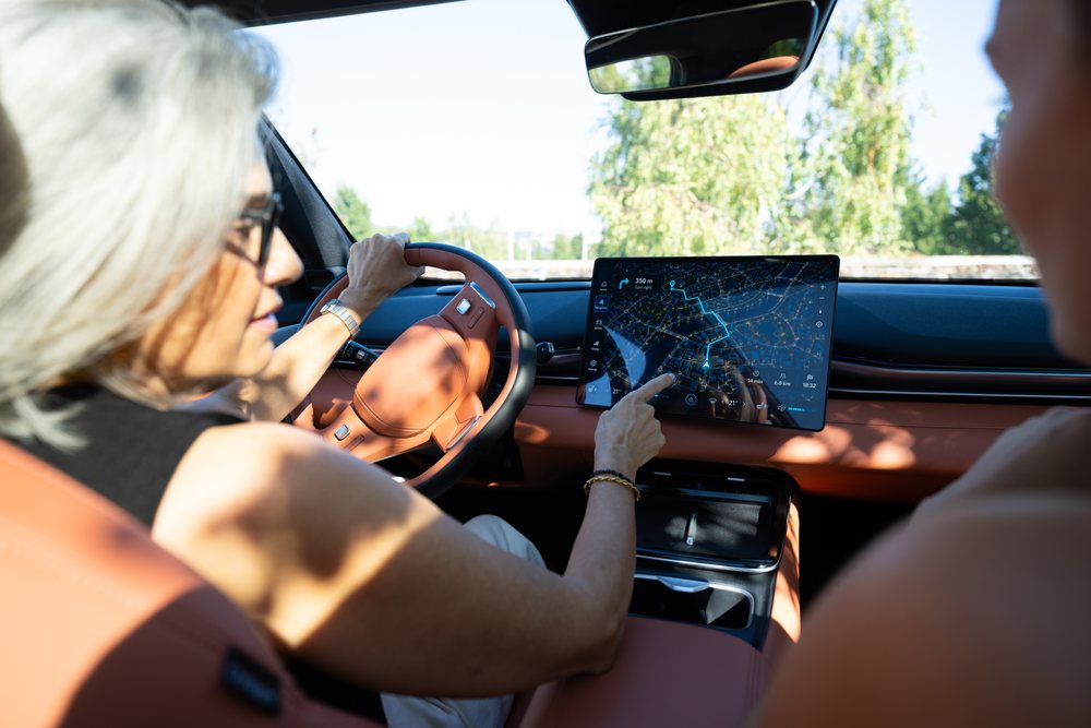 White woman driver using touchscreen navigation system