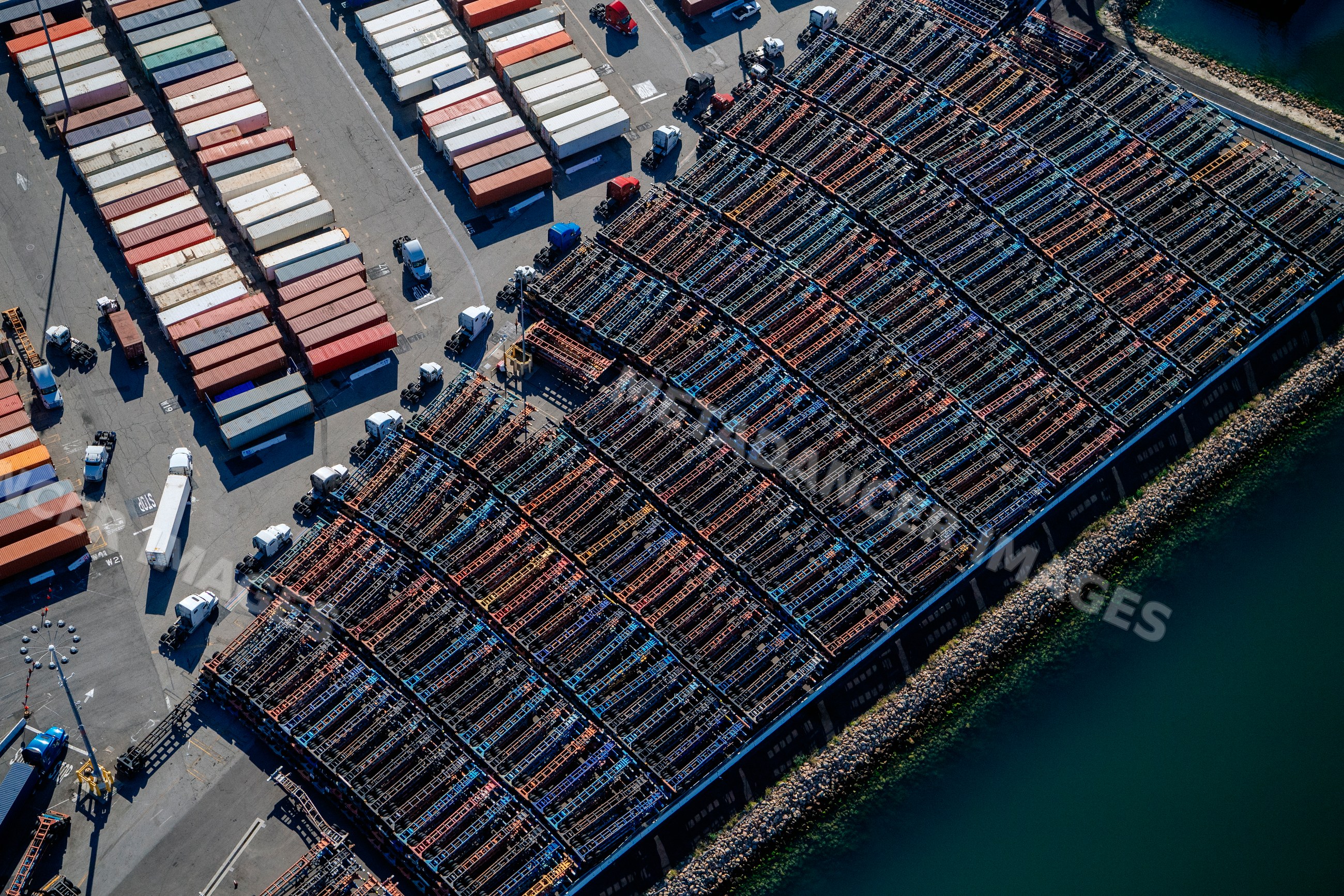 Aerial view of container ships and trucks at dockyard in a beach