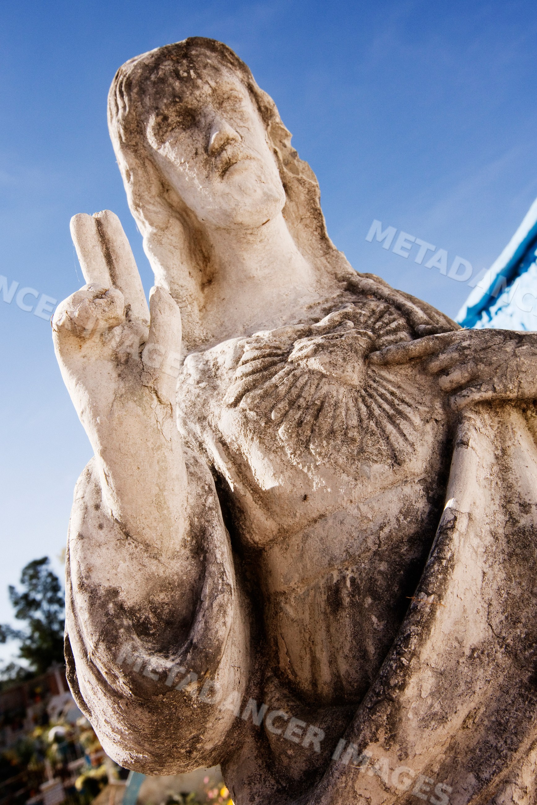 Weathered stone statue of jesus christ making blessing gesture
