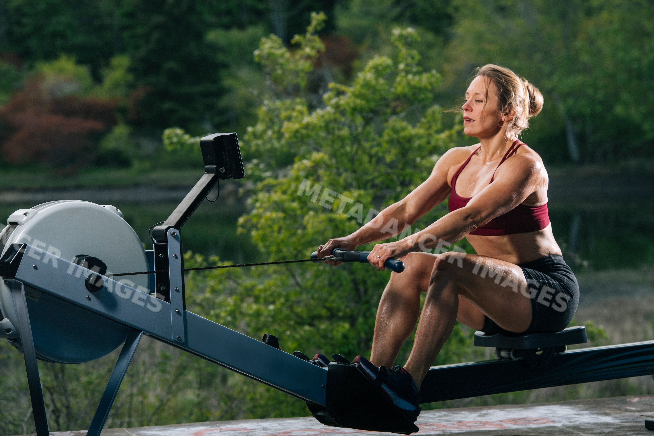 White woman exercising on rowing machine outdoors