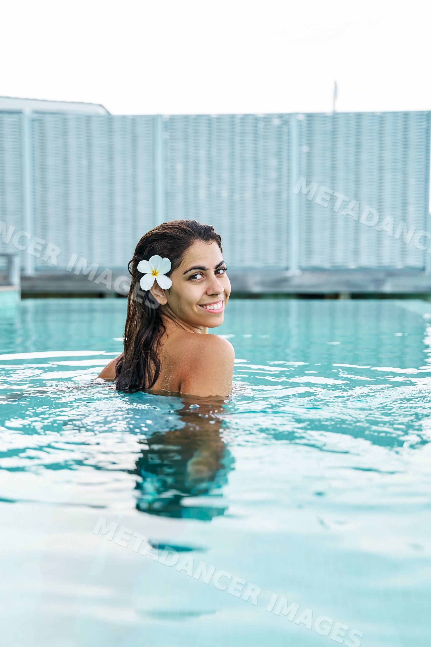 A white woman smiling while swimming in a pool
