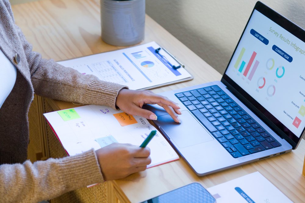 African American person working on laptop with survey infographic