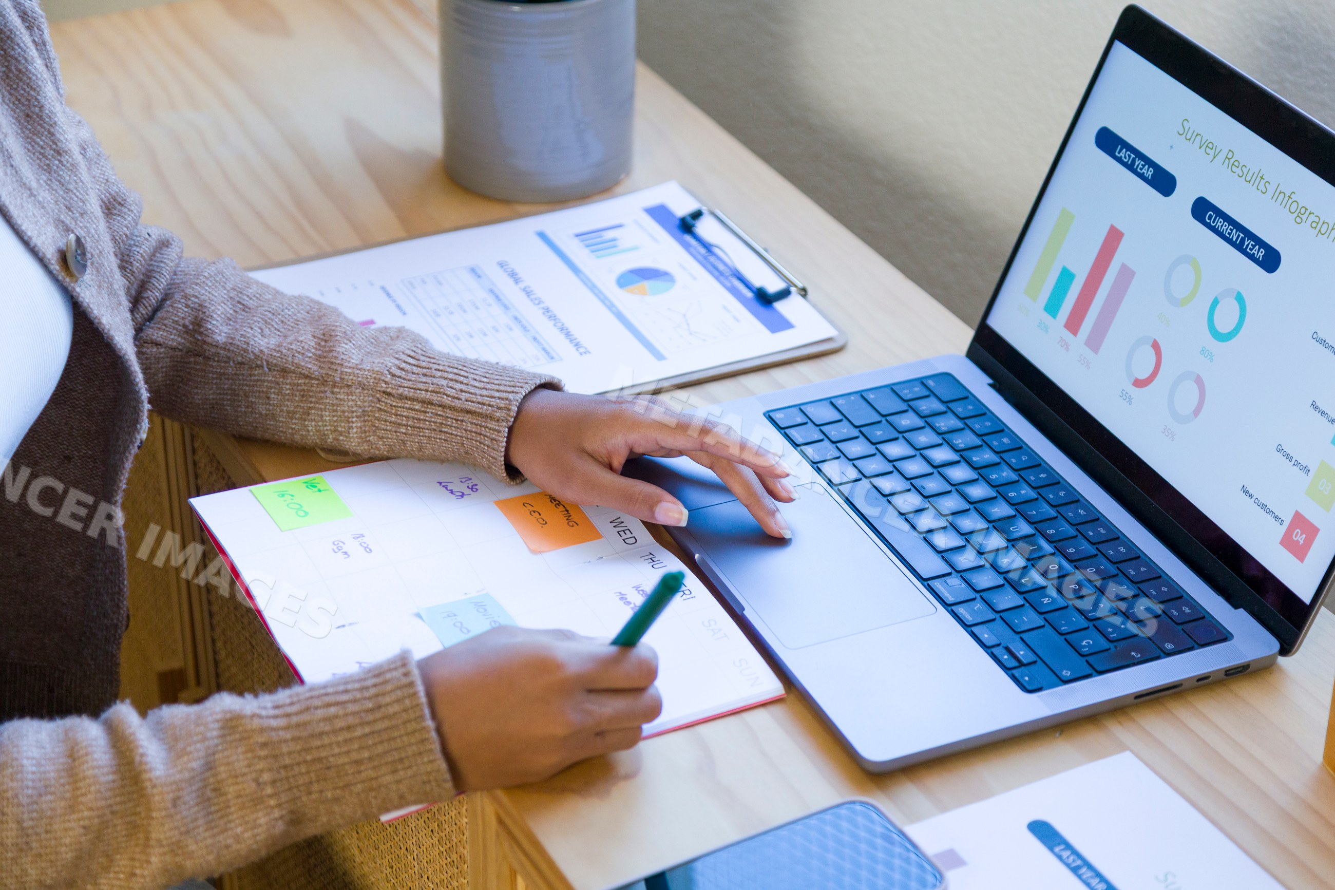 African American person working on laptop with survey infographic