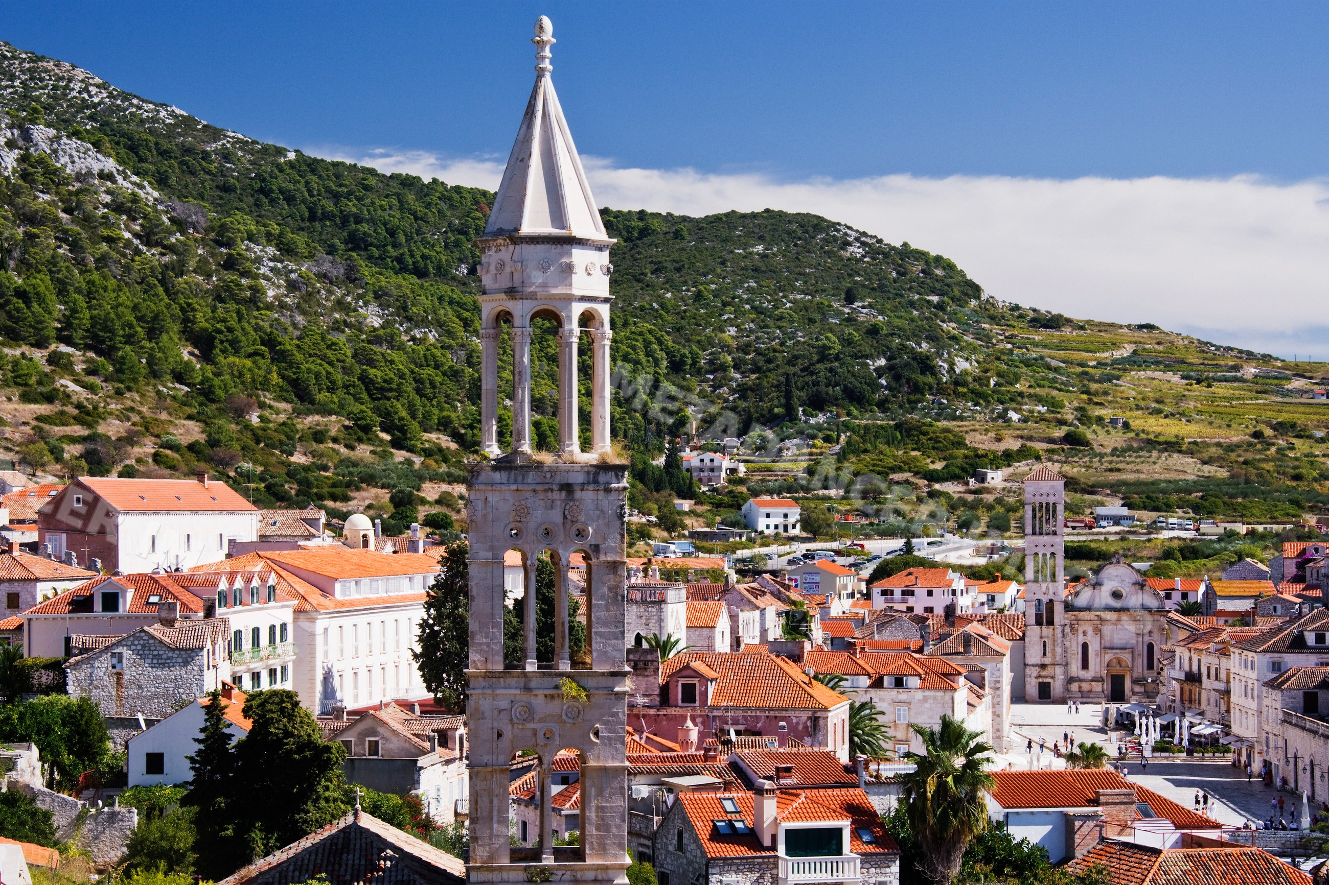 Town of hvar with stone bell tower and red tile roofs