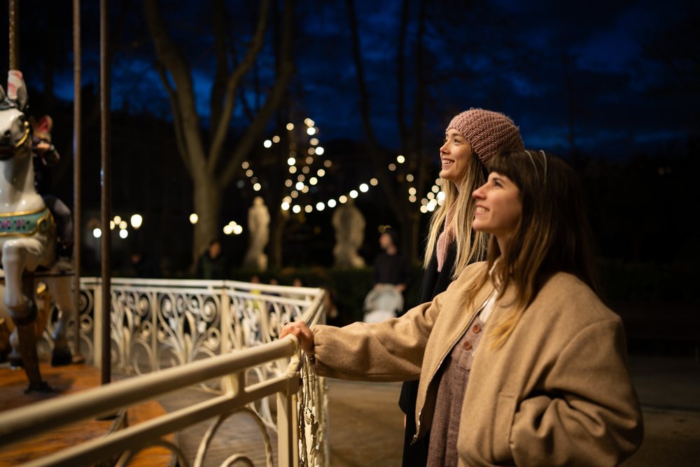 Two white women enjoying carousel ride