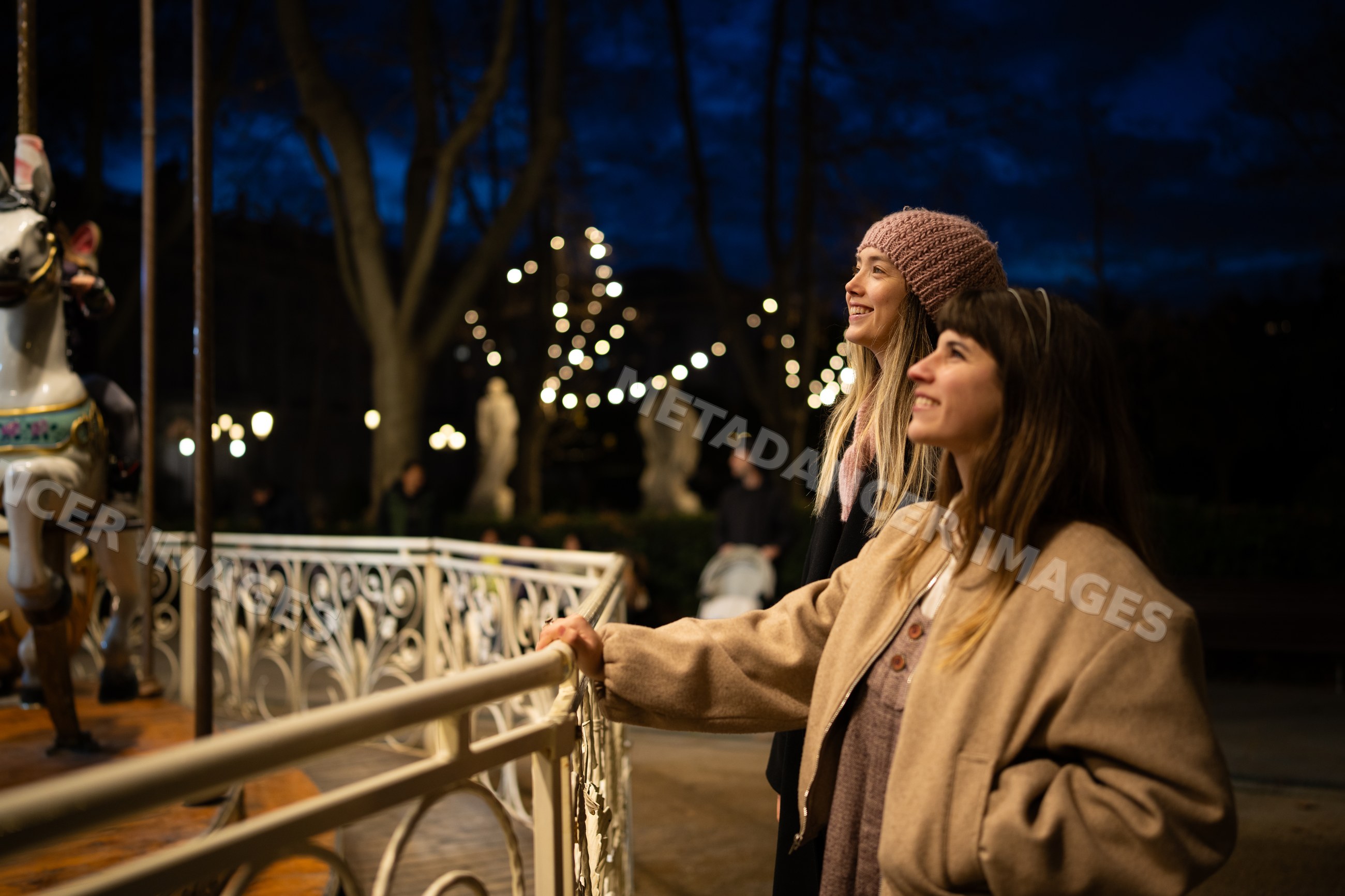 Two white women enjoying carousel ride