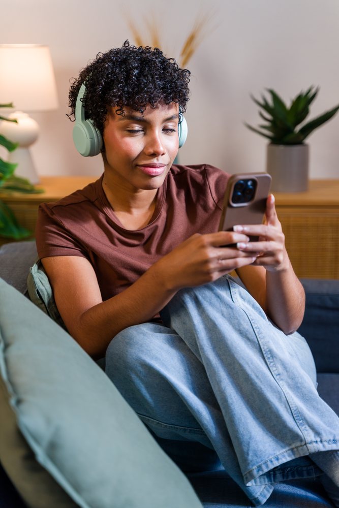 African American woman relaxing on couch with headphones