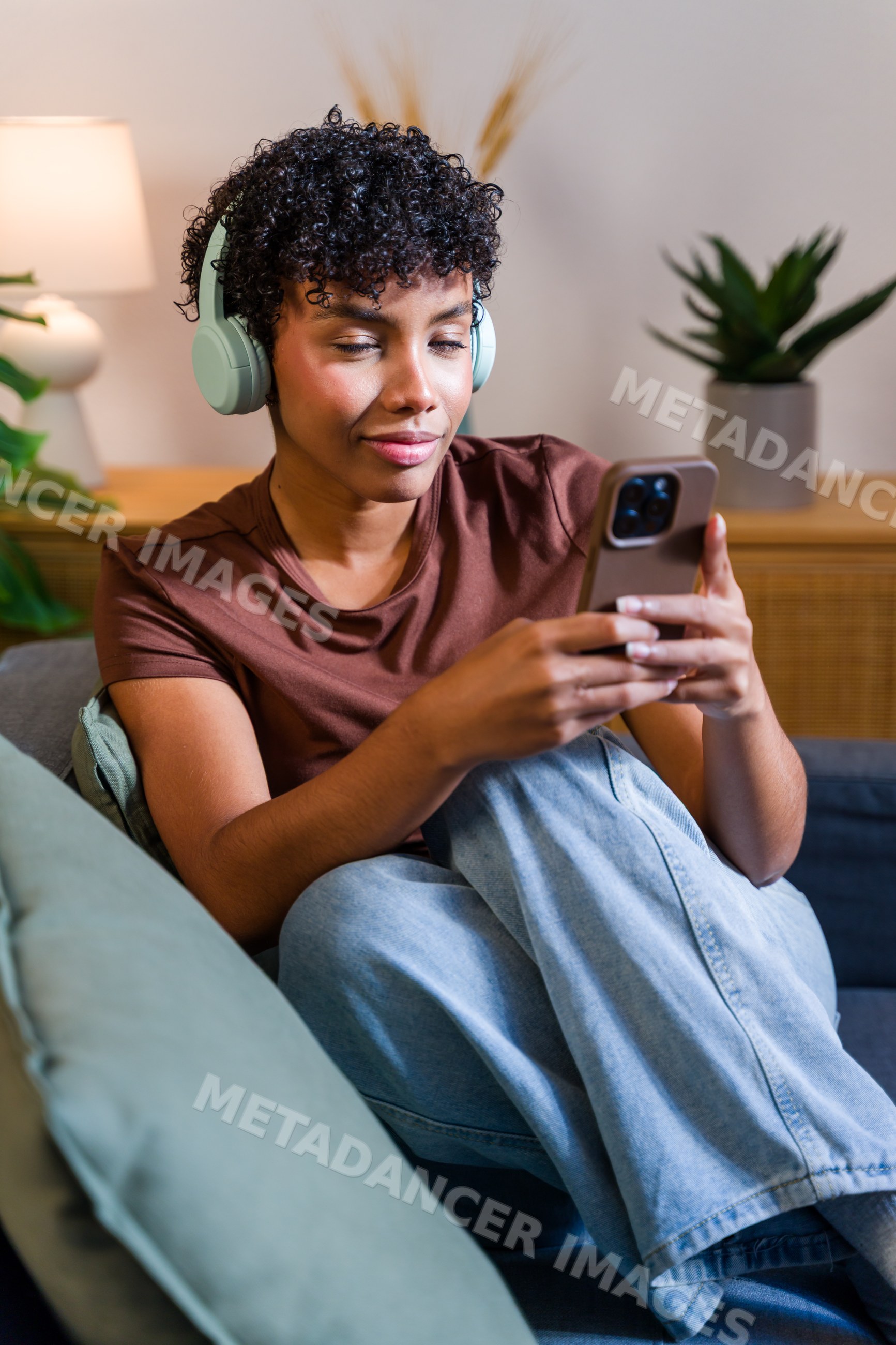 African American woman relaxing on couch with headphones