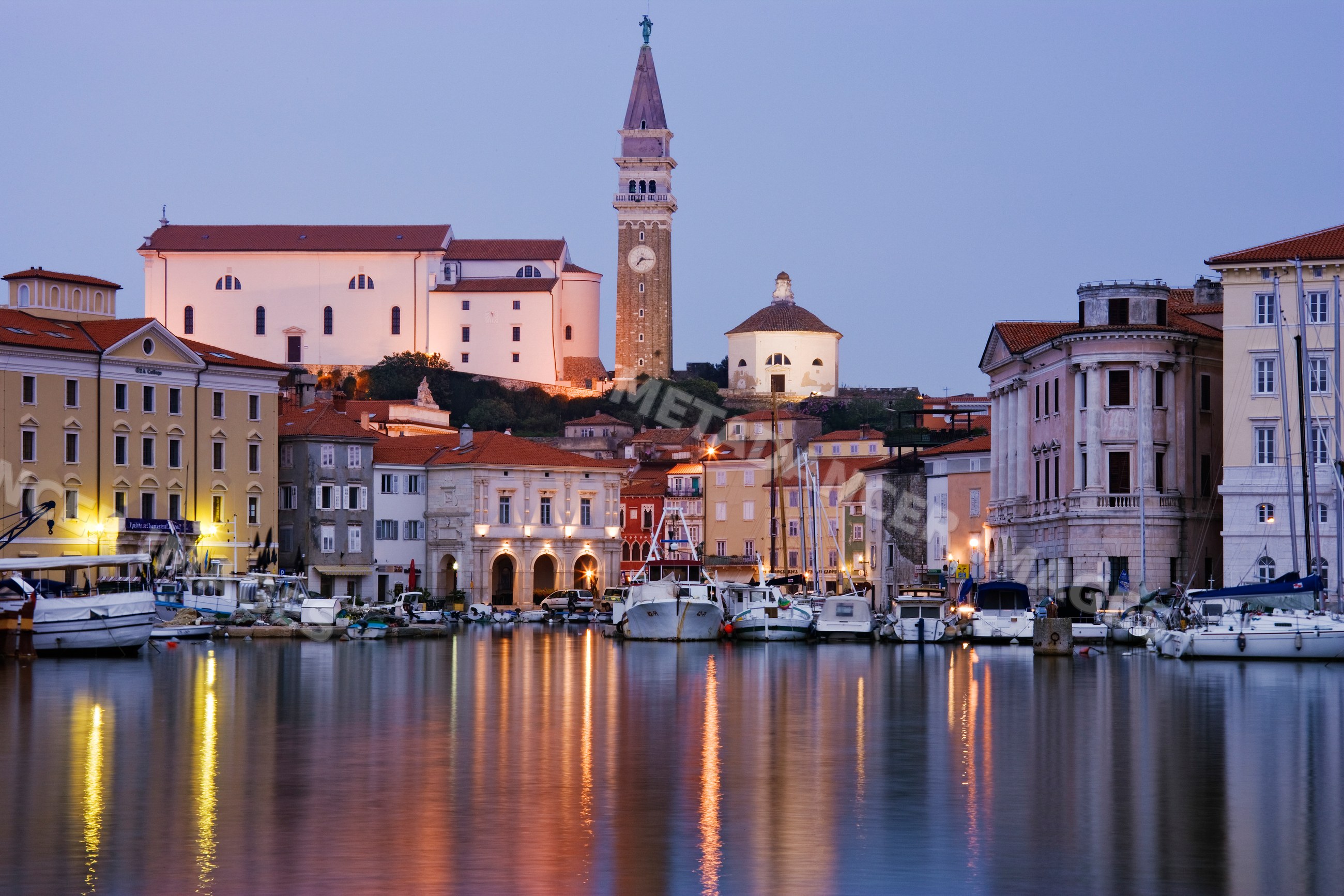 Town of piran harbor with boats and historic buildings
