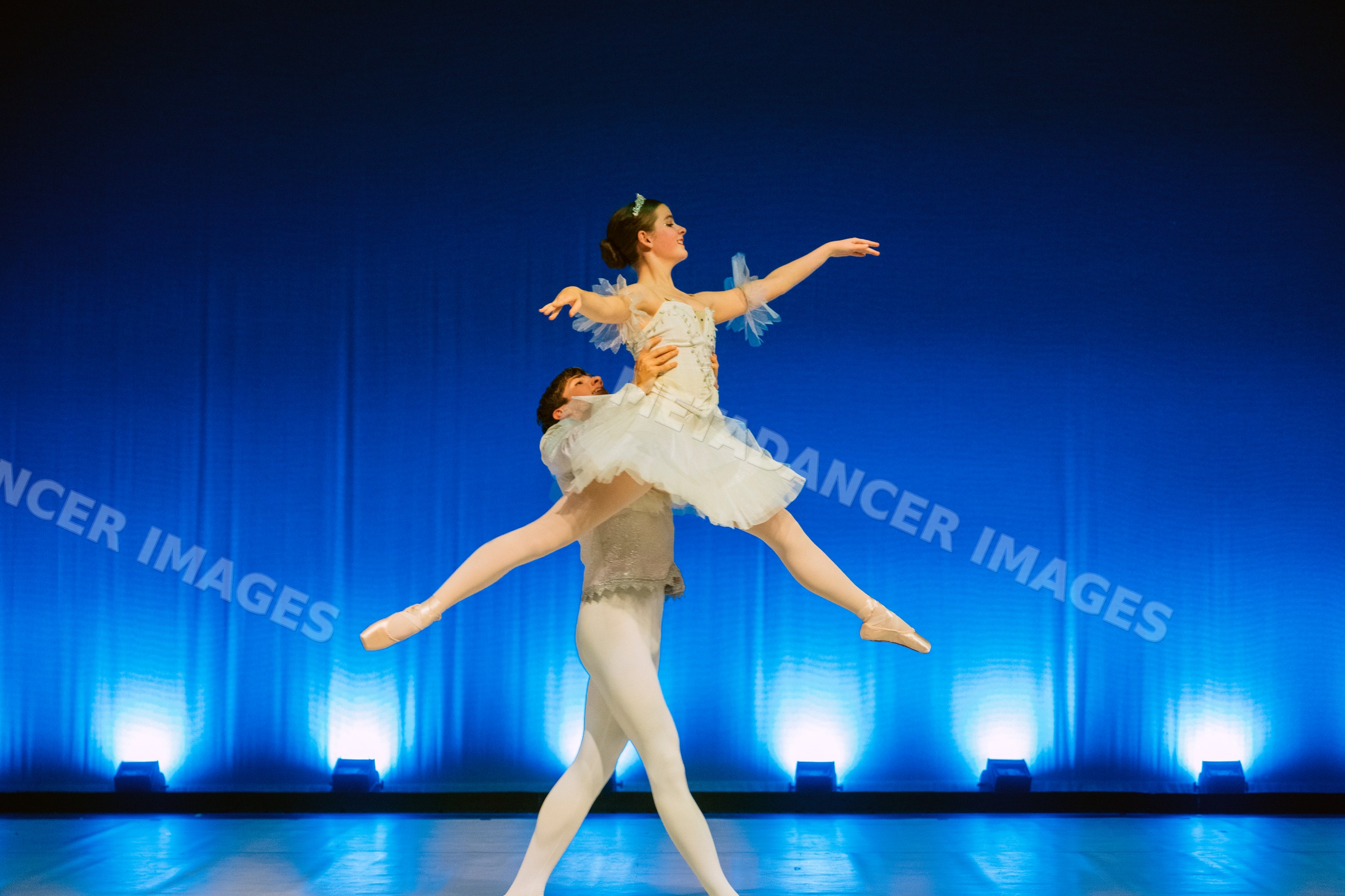 Ballet dancers perform a classical lift on stage