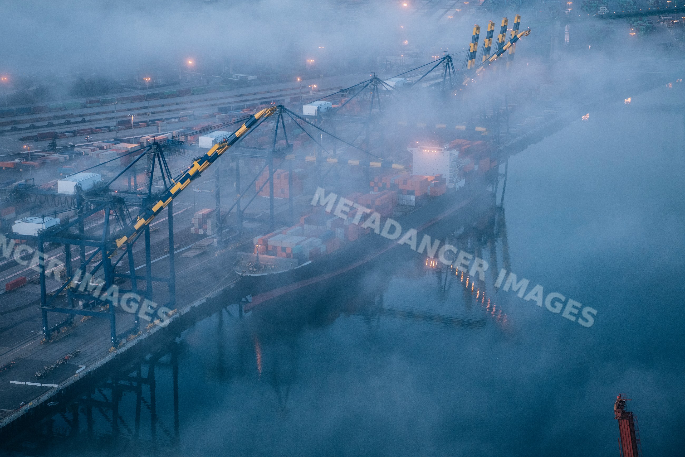 Cargo container ship docked in foggy shipping port at Long Beach