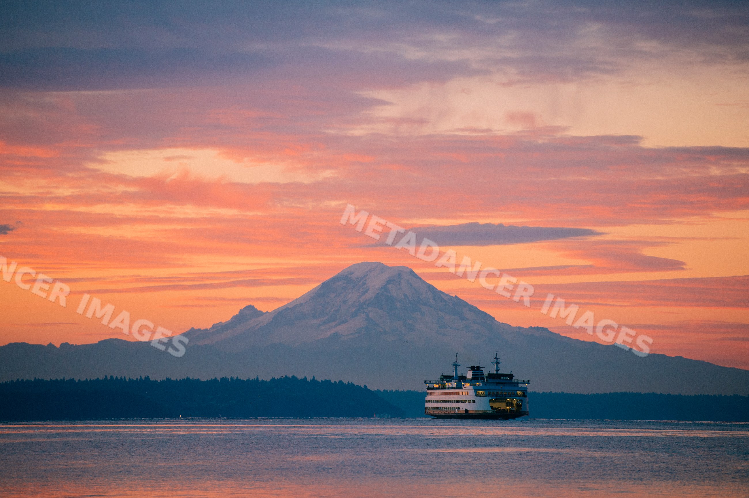 Ferry crossing puget sound at sunset with mount rainier background