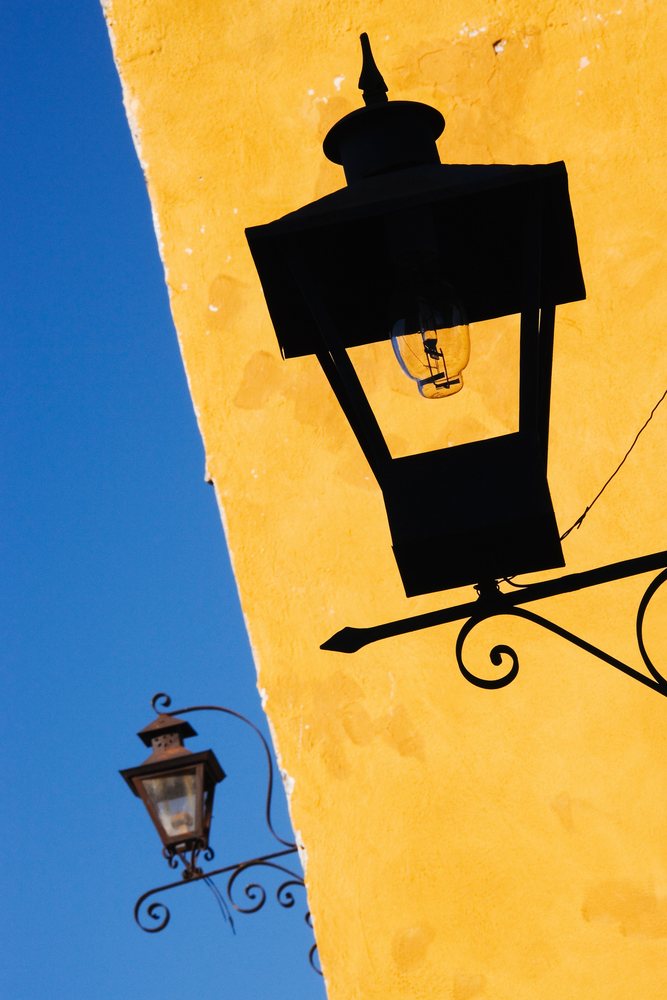 Lamppost on yellow wall with clear blue sky, mexico