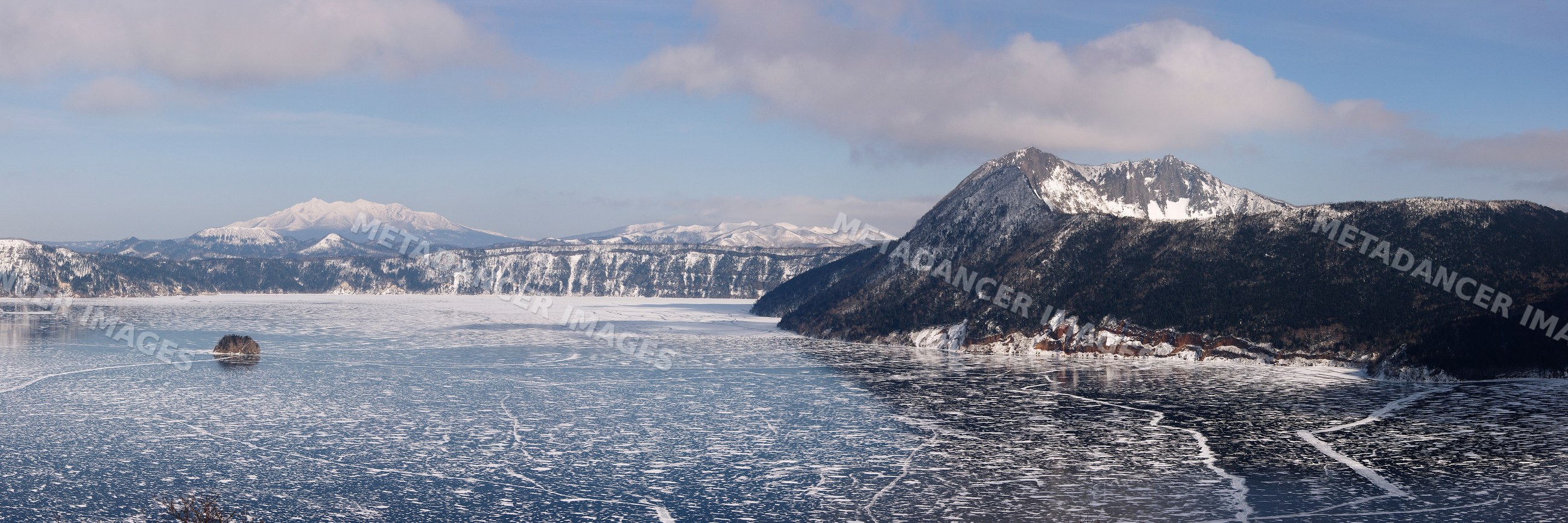 Frozen lake mashu with snow-covered mountains and island japan